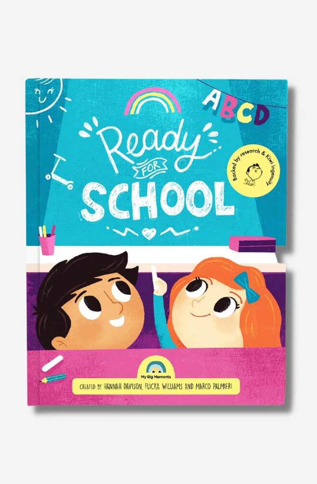 The cover of MY BIG MOMENTS' children's book, "Ready for School," showcases illustrated characters: a boy with black hair and a girl with red hair, both smiling and looking up. The colorful design supports child development by incorporating educational elements such as the letters "A B C D" and a small rainbow.