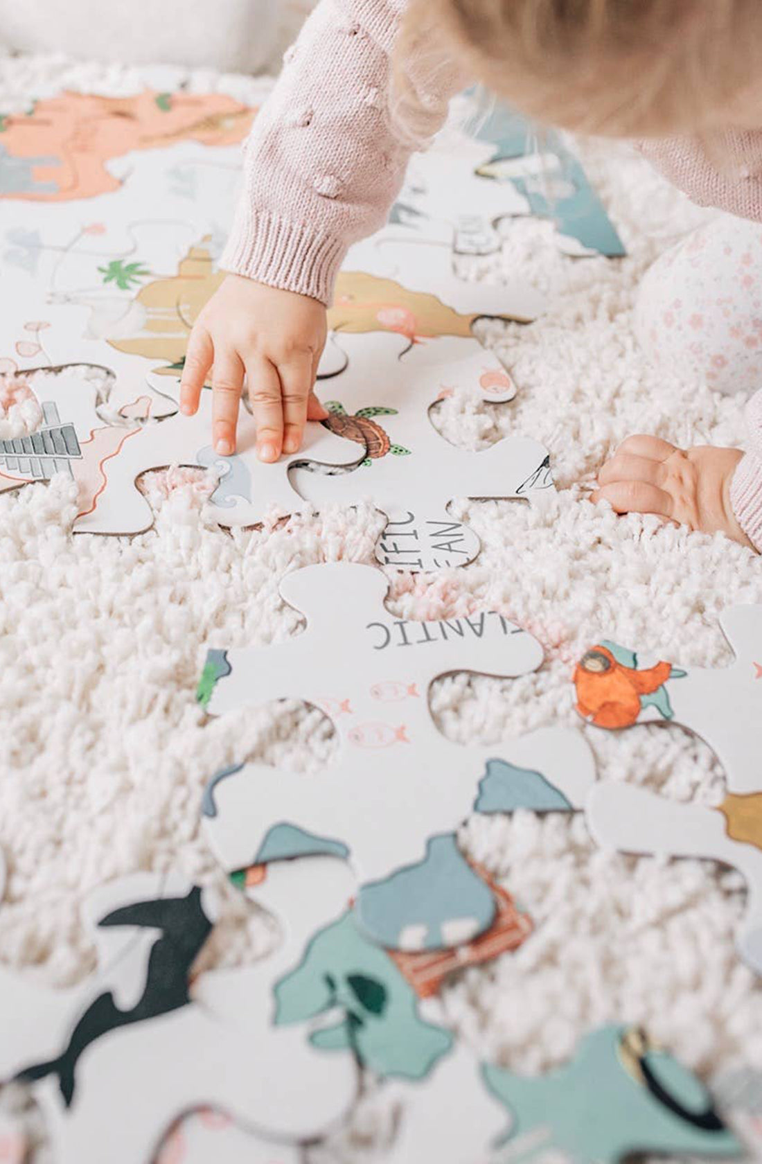 A girl playing with the world map puzzle.