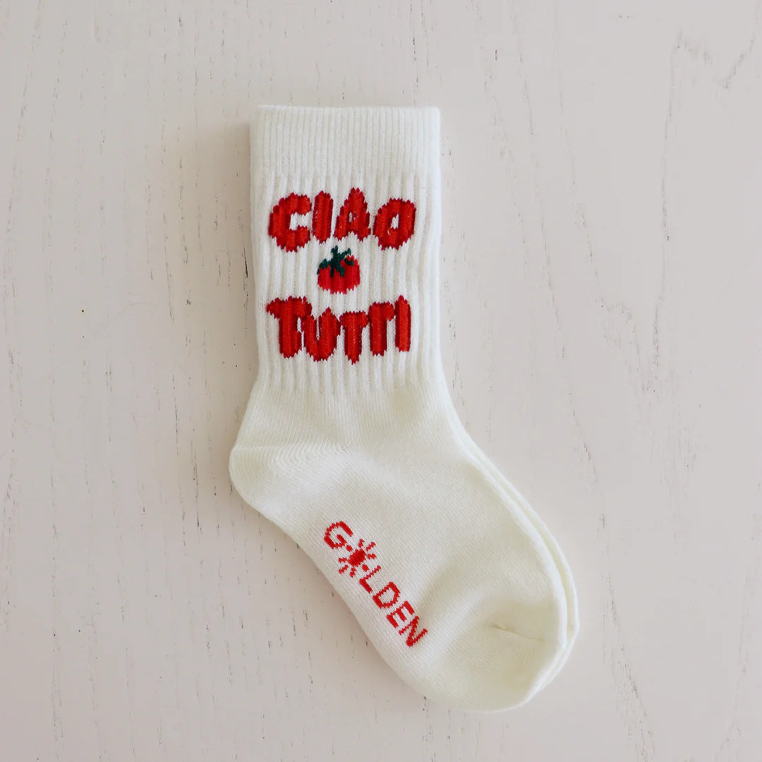 The Ciao Tutti Socks Cream by GOLDEN CHILDREN feature stylish ribbed design with playful red "CIAO TUTTI" text, a small red flower above the heel, and "GOLDEN" along the foot. Perfect for adding charm to any outfit, they are displayed on a light-colored surface.