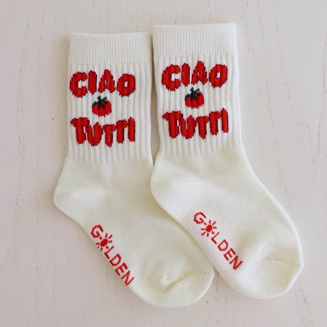 The Ciao Tutti Socks Cream by GOLDEN CHILDREN feature a cream design with red "CIAO Tutti" and a playful tomato graphic. The soles have bright red "GOLDEN" text, adding fun for children or anyone looking to add charm to their outfit.