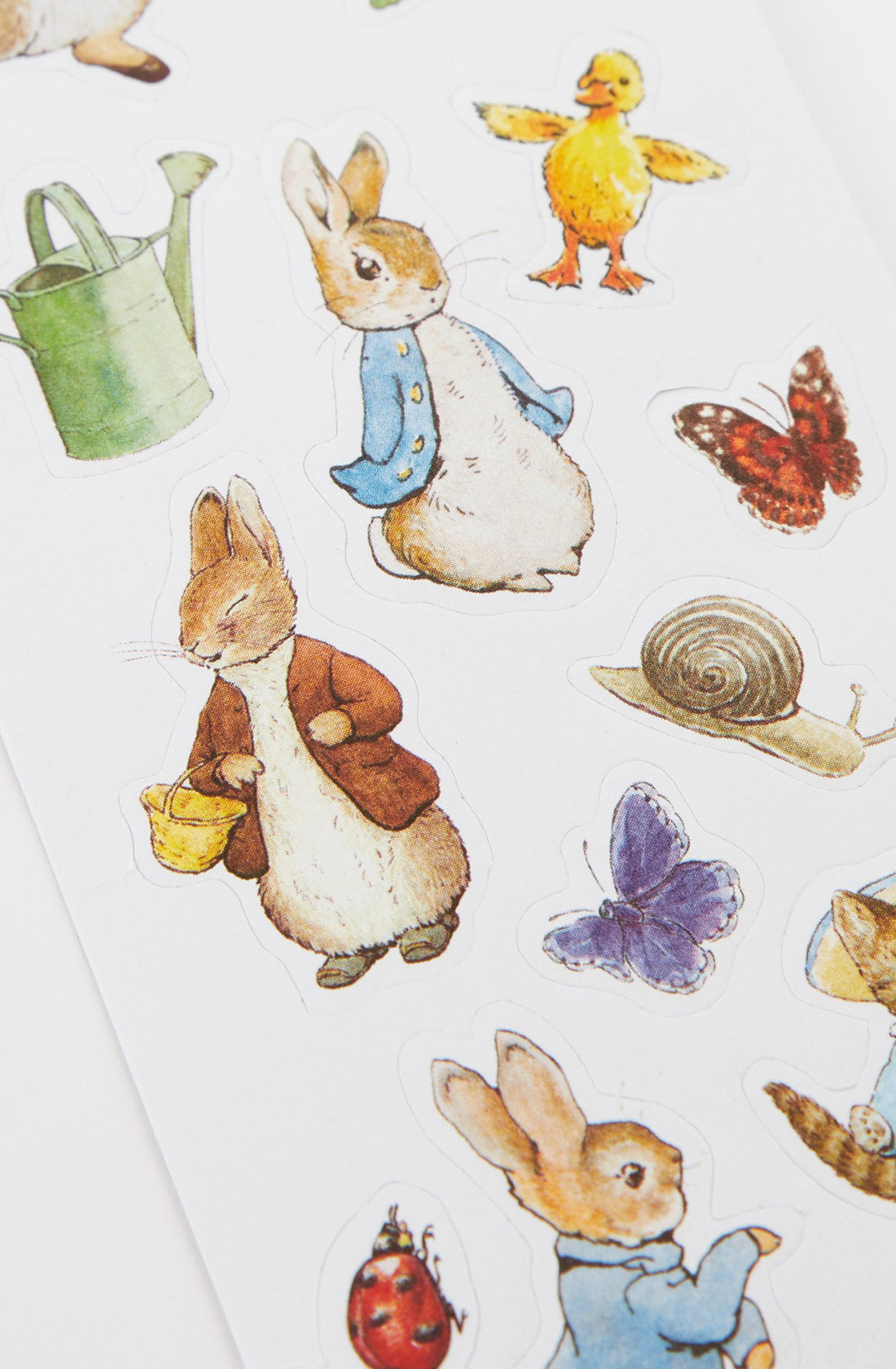 Introducing the Peter Rabbit & Friends Sticker Roll by MERI MERI, a delightful collection of colorful stickers showcasing charming illustrations of animals and objects. Perfect for party bag gifts, these whimsical, vintage-inspired designs feature rabbits dressed in clothes reminiscent of Peter Rabbit stickers, along with adorable images of a duckling, butterfly, snail, ladybug, and more.