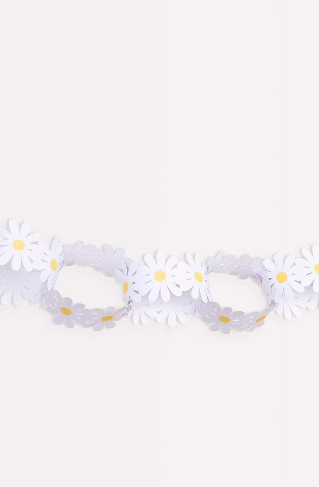 Displayed against a plain background, the Daisy Paper Chains from MERI MERI showcase an enchanting strand of paper garlands. Each white daisy-shaped cutout, featuring a vibrant yellow center, is linked together seamlessly to create a delightful and charming decorative chain that is perfect for Spring decorations.