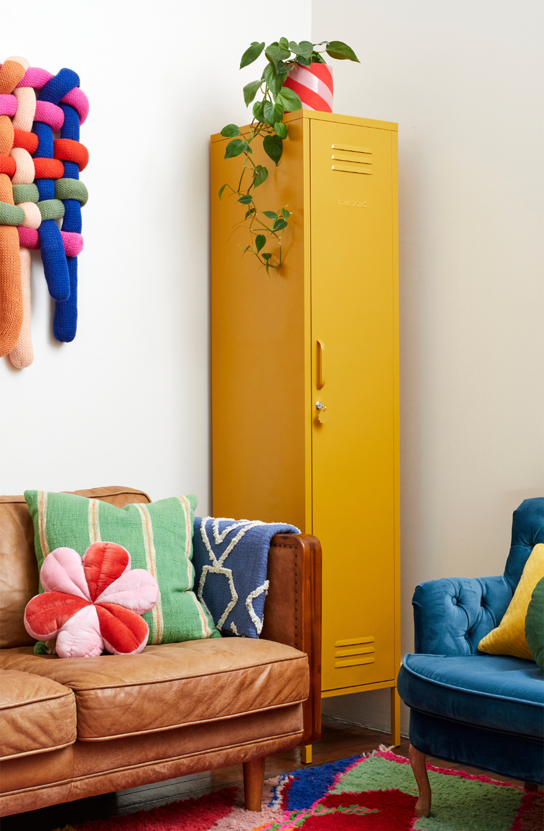 The skinny locker in mustard next to a couch.