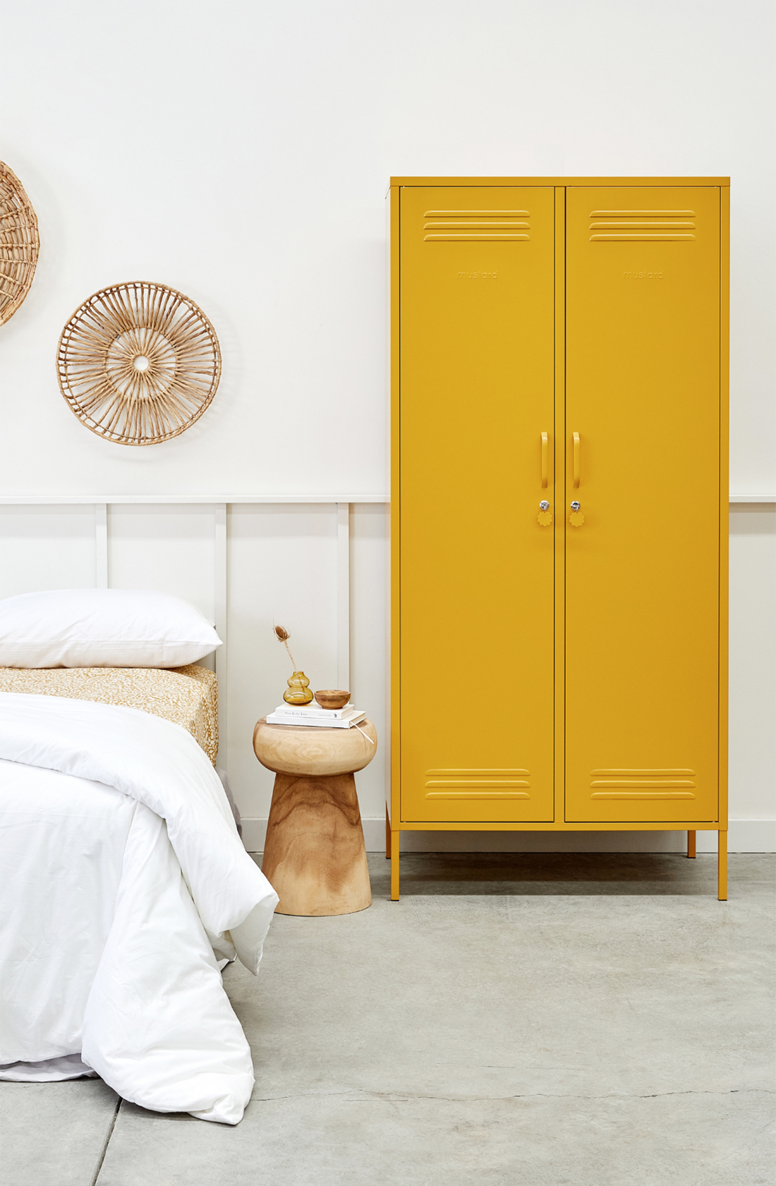 The twinny locker in mustard next to a bed.