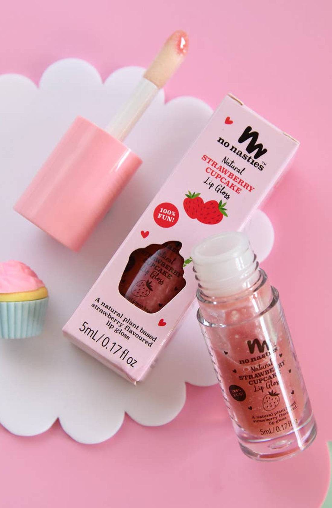 Two no nasties natural strawberry cupcake lip gloss, one in its packaging and the other propped up against the packaging with the lid off.