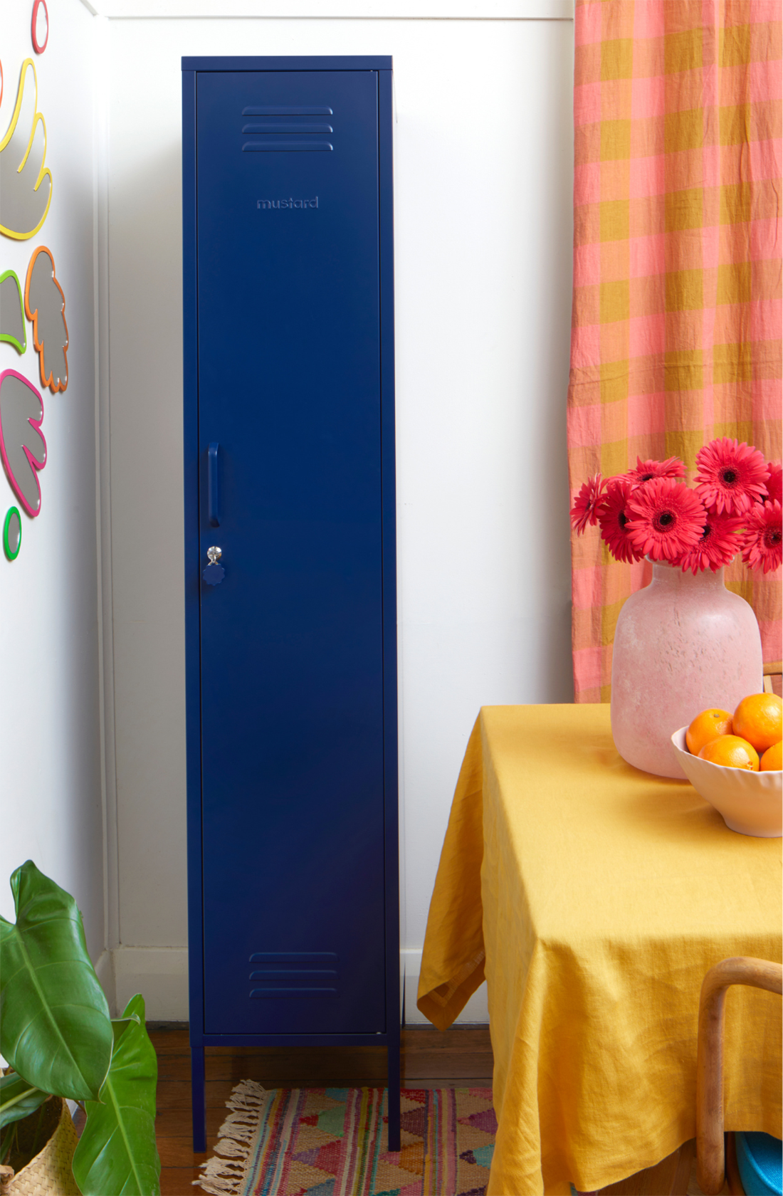 The skinny locker in navy next to a table.