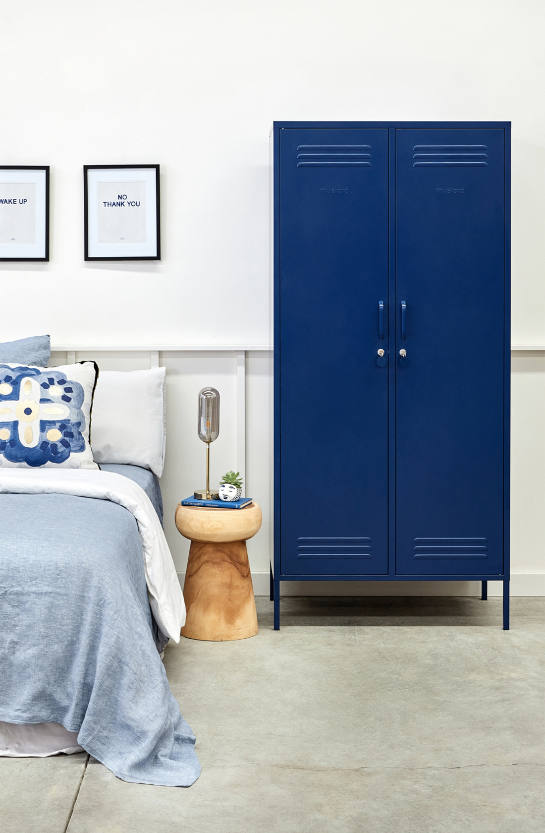 The twinny locker in navy next to a bed.