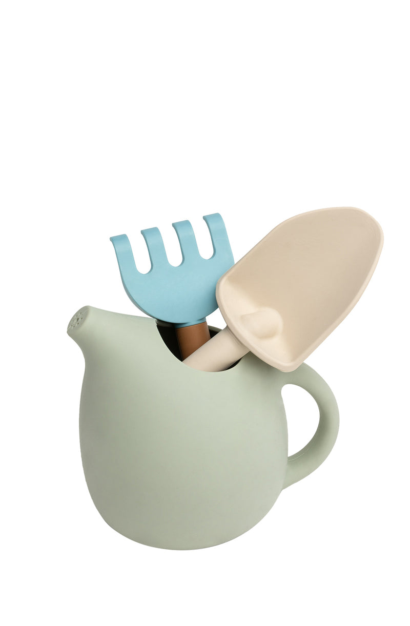 Rake and spade placed inside watering can on white background