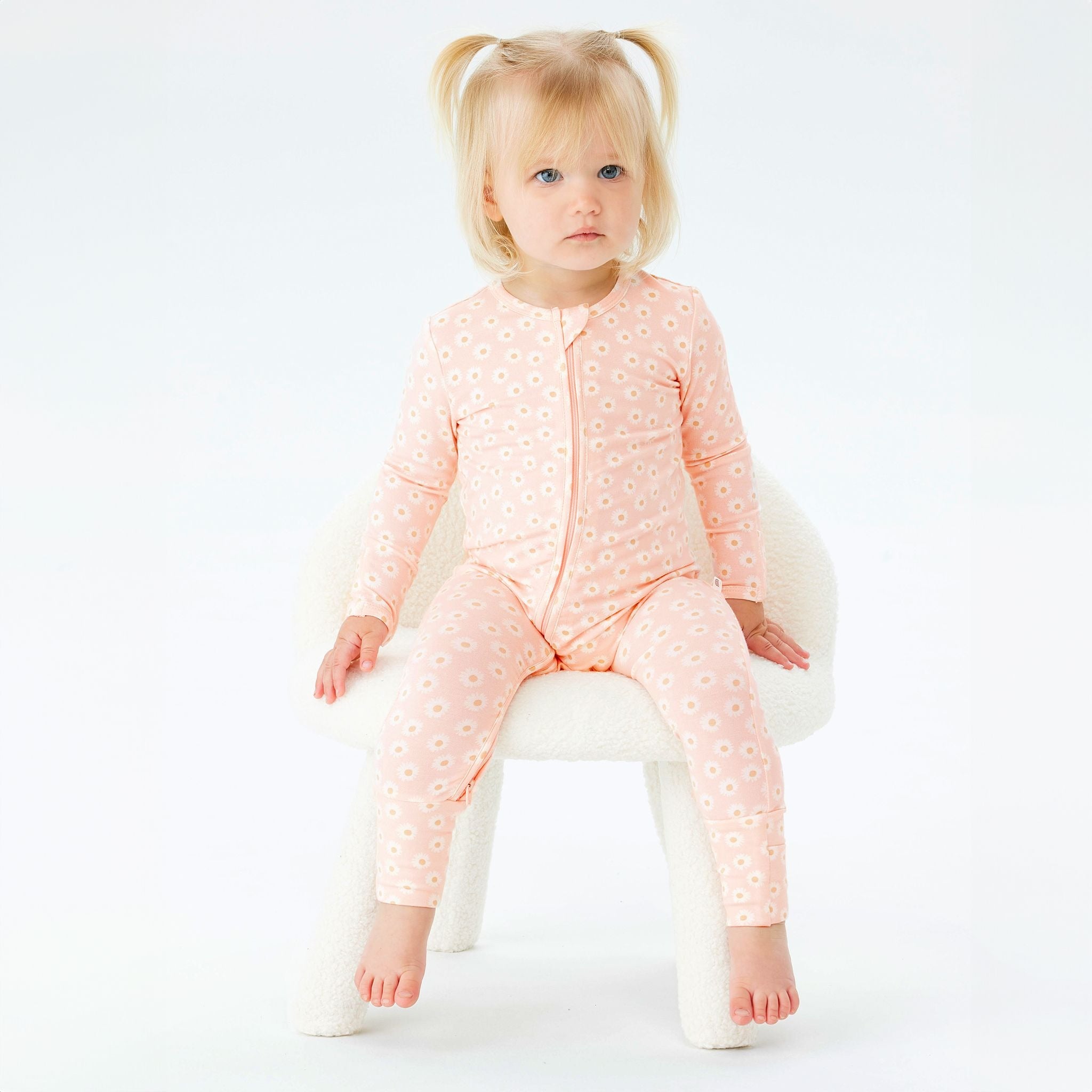 A Toddler wearing the Day or Night Onesies Daisy Charm.