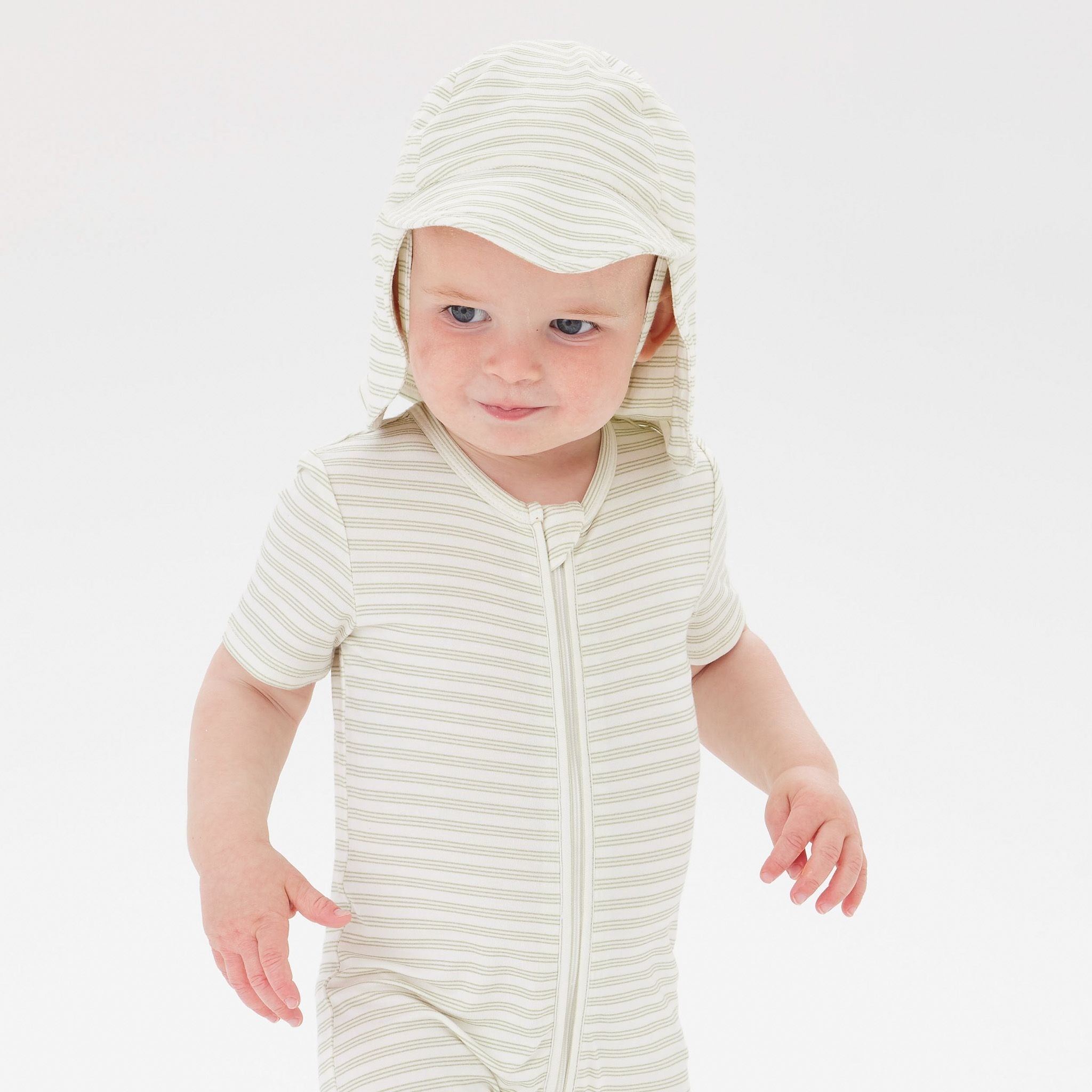 A Toddler wearing the Day or Night Short Sleeve Onesie Sage Stripe with matching hat.