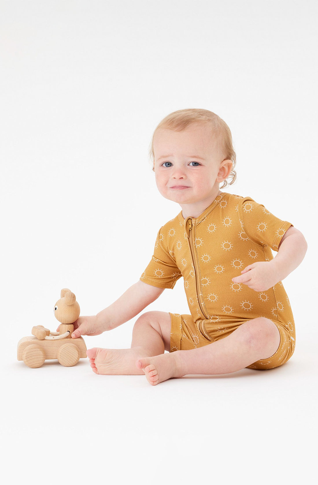 A Toddler wearing the Day or Night Short Sleeve Onesie Sunrise playing with a toy.