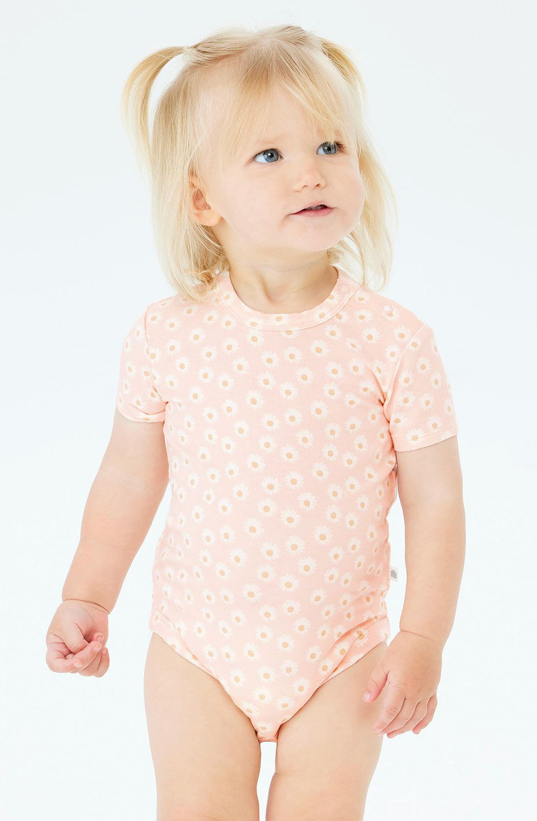 A baby wearing the KYND BABY Comfy Bodysuit Short Sleeve Daisy Charm.