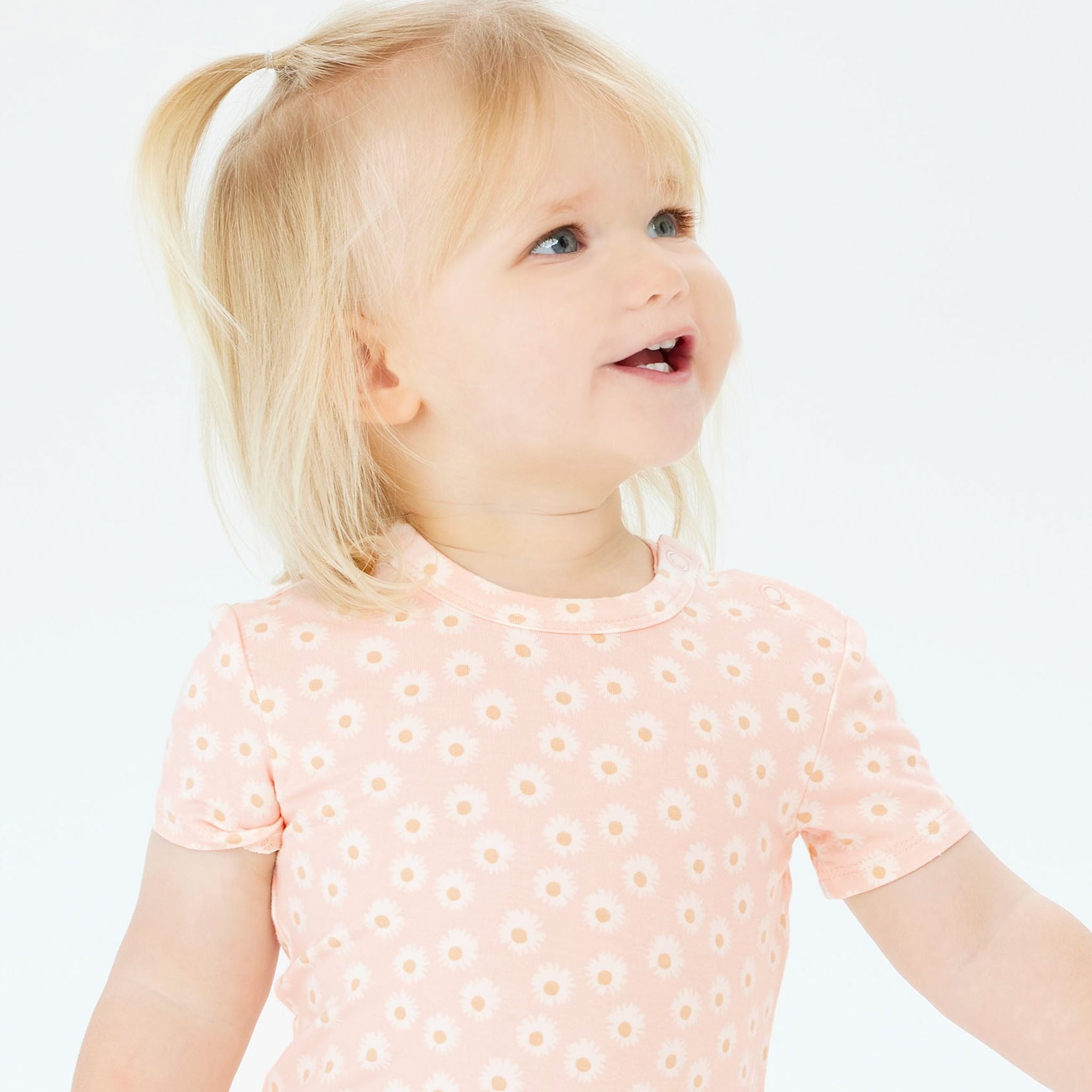 A baby wearing the KYND BABY Comfy Bodysuit Short Sleeve Daisy Charm.