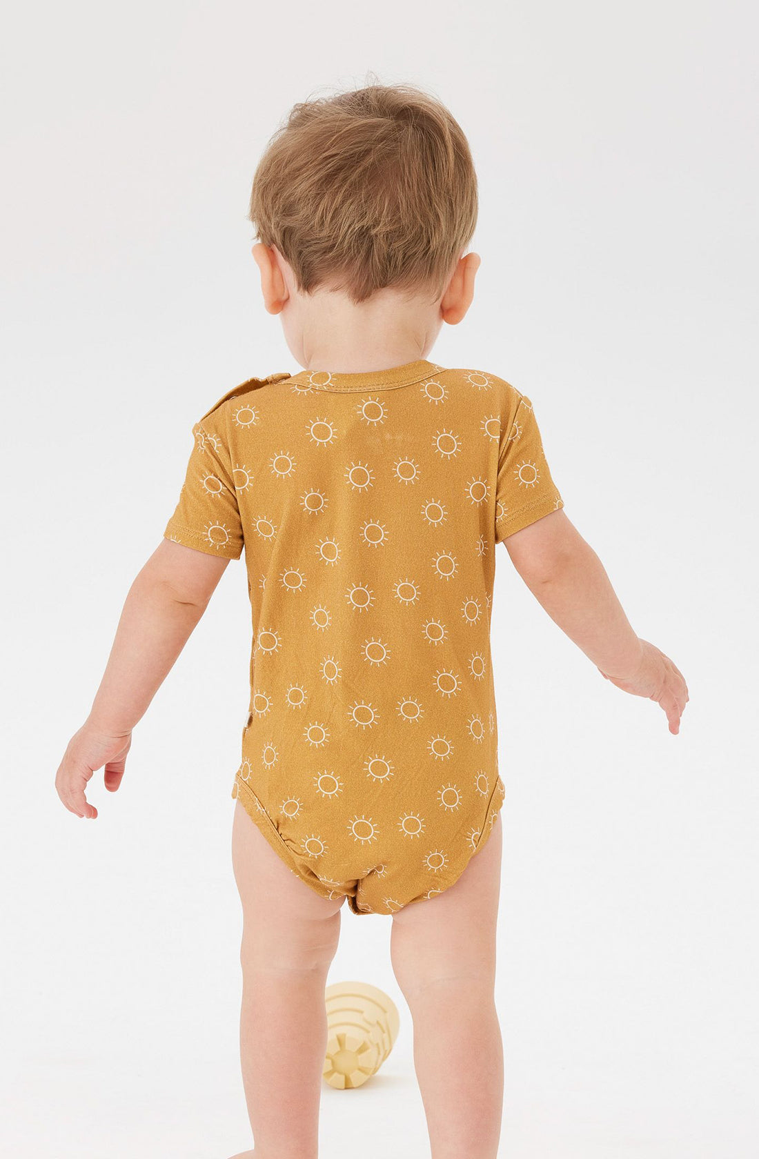 A Toddler wearing the KYND BABY Comfy Bodysuit Short Sleeve Sunrise.