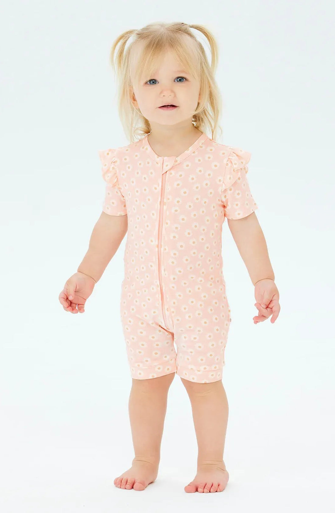 A Toddler wearing the Day or Night Short Sleeve Frill Onesie Daisy Charm.