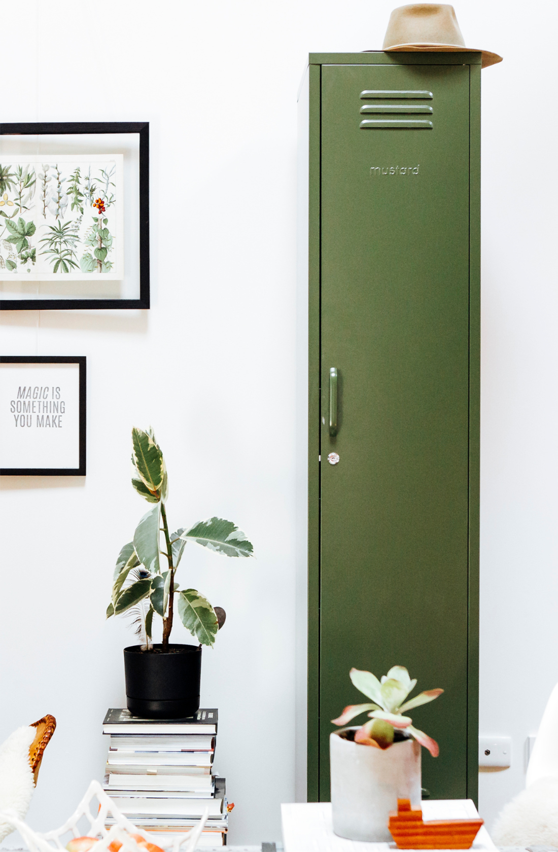 The skinny locker in olive next to plants.