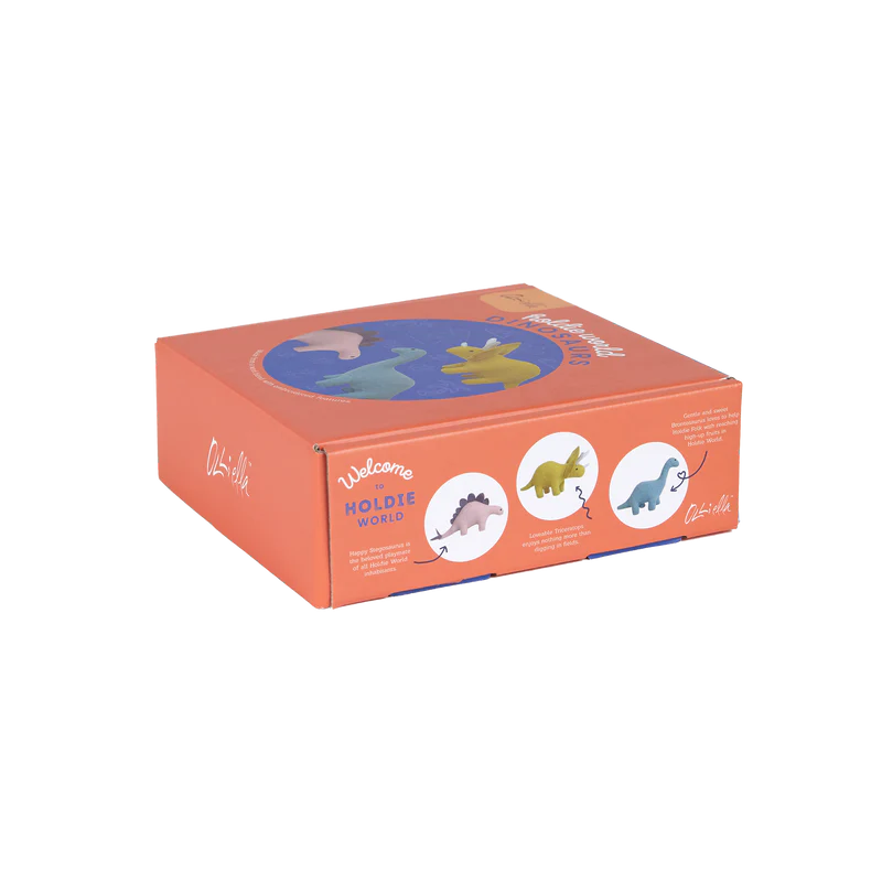 A rectangular orange and purple toy box, branded "Welcome to Holdie World" from OLLI ELLA, showcases illustrations of three Holdie Dinosaurs. Each dinosaur is displayed in circular frames on the front of the box in blue, green, and yellow colors with their names and unique shapes. Ideal for housing your prehistoric pals!