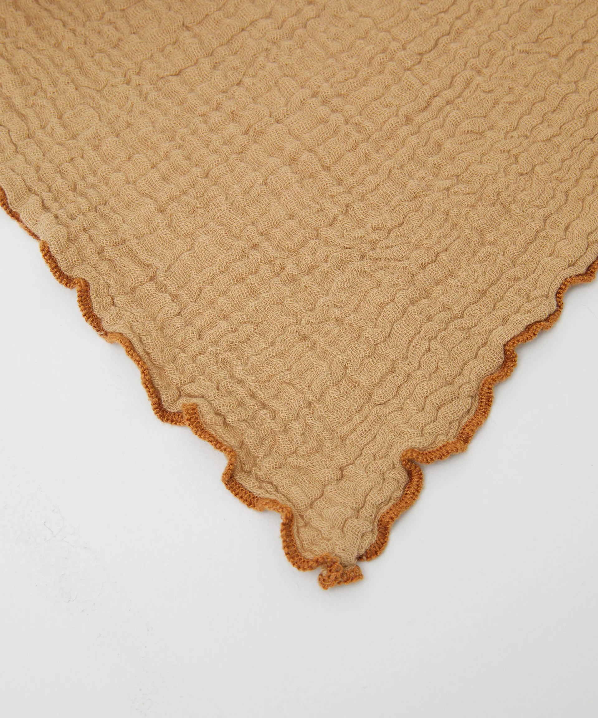 An extra-large muslin wrap, Swaddle Cacao by PHILÉ, is showcased flat against a white background. With wavy beige edges, orange trim, and intricate patterns, it belongs to the Cotton Classics Collection and is made from Oeko-Tex Certified Cotton.