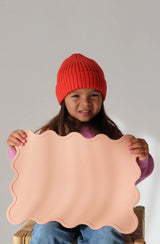 Girl in red beanie holding the melon placemat
