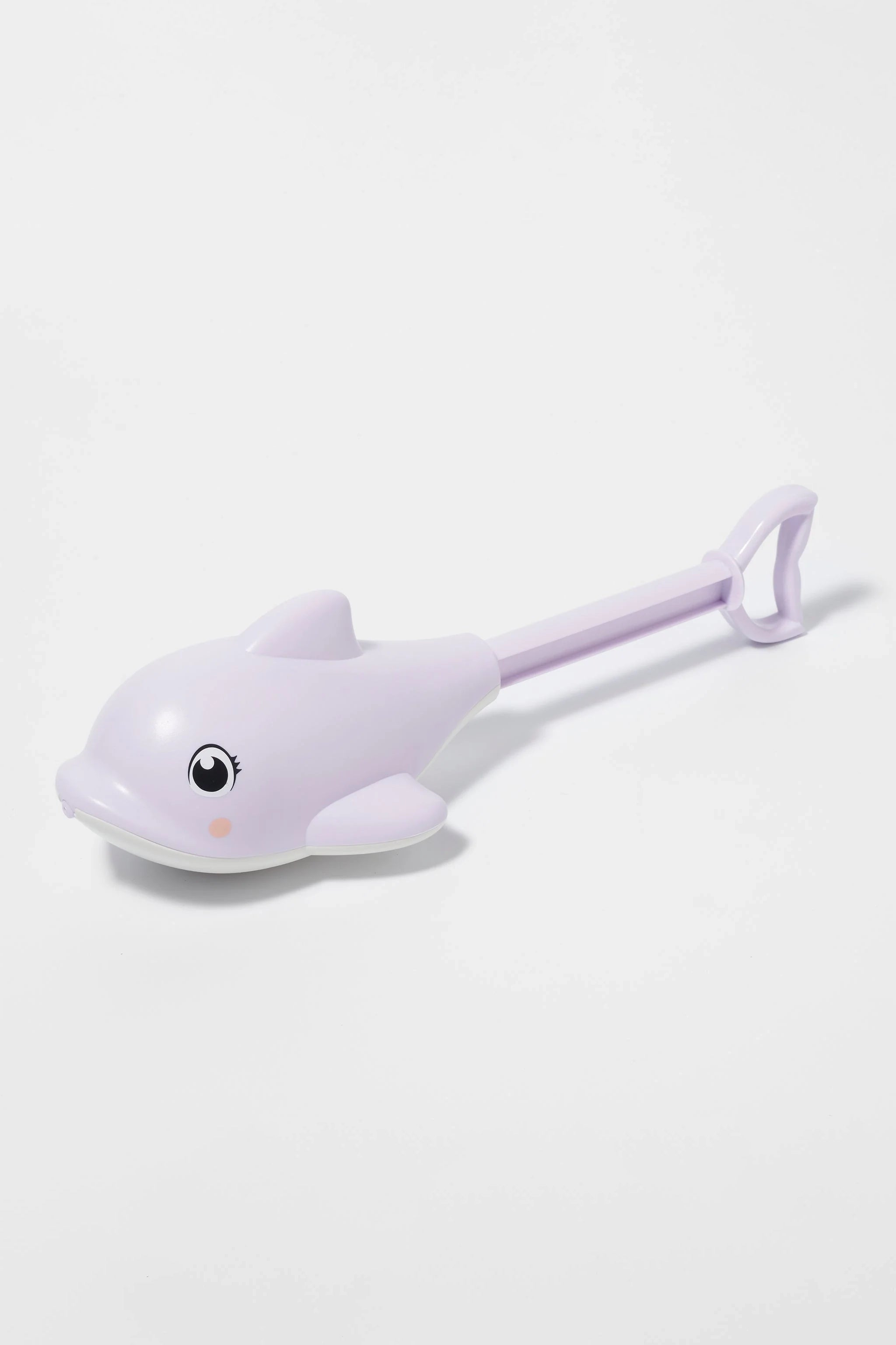 The Dolphin Water Squirter by SUNNYLIFE is a light purple children's toy made from ABS PVC. It features a dolphin shape with a long handle and a heart-shaped loop at the end. The dolphin has a smiling face, complete with an eye and blush mark. The toy is positioned against a plain white background.