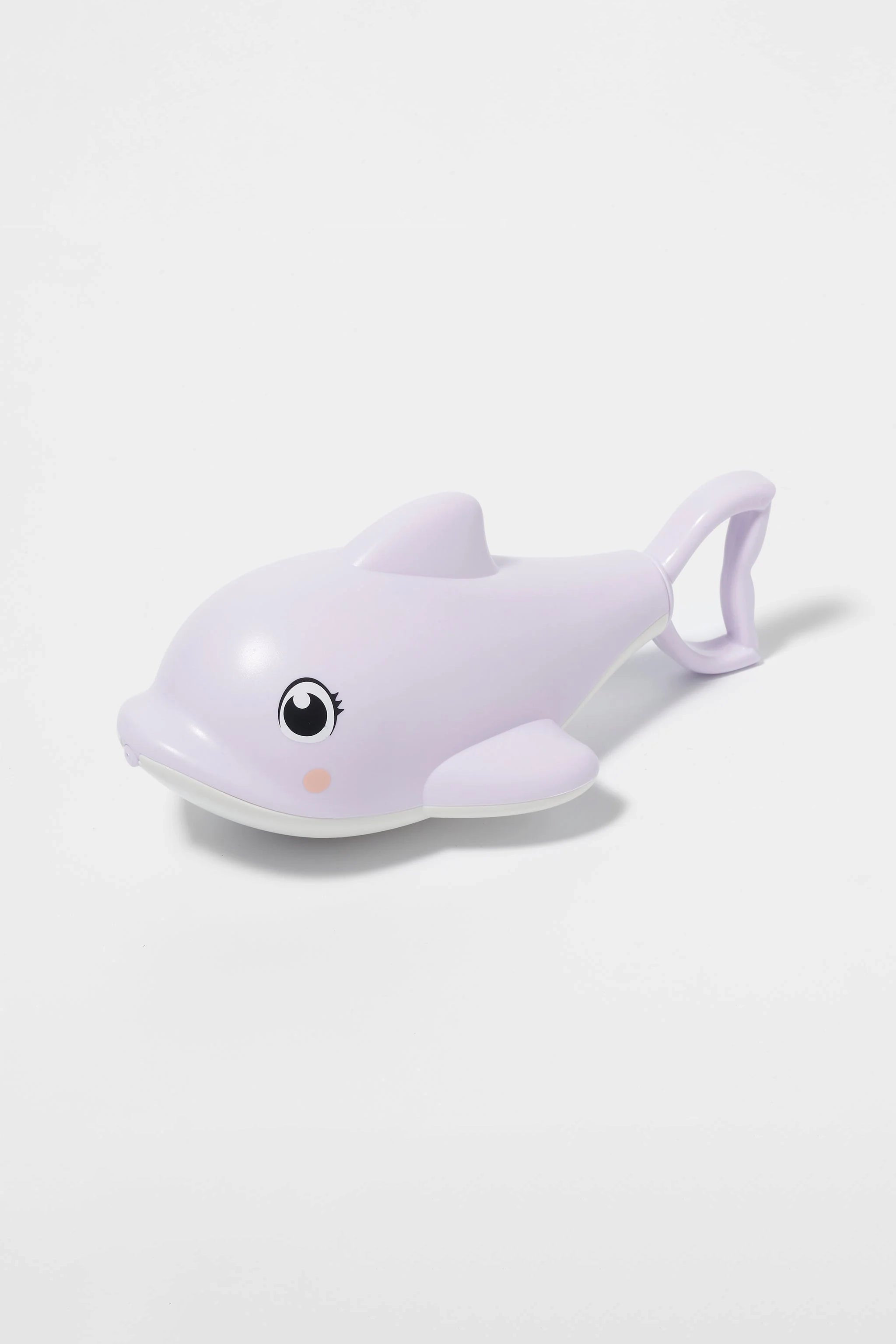 The SUNNYLIFE Dolphin Water Squirter, a light purple plastic toy with a large eye and small pink cheek, is lying on a white surface. Made from ABS PVC, the dolphin features a handle on its back for easy holding or carrying.