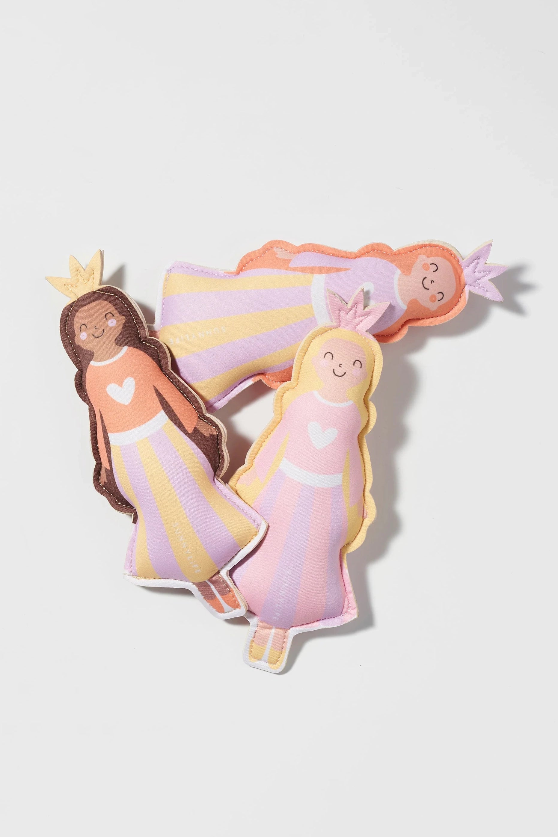 A set of 3 Princess Swan Dive Buddies by SUNNYLIFE, featuring plush dolls with crowns and smiling faces, are laid out on a white background. Each doll is adorned in pastel-colored dresses in shades of pink, purple, and orange, with light-colored stripes and a heart symbol on the chest. They are crafted from durable neoprene material for extra longevity.