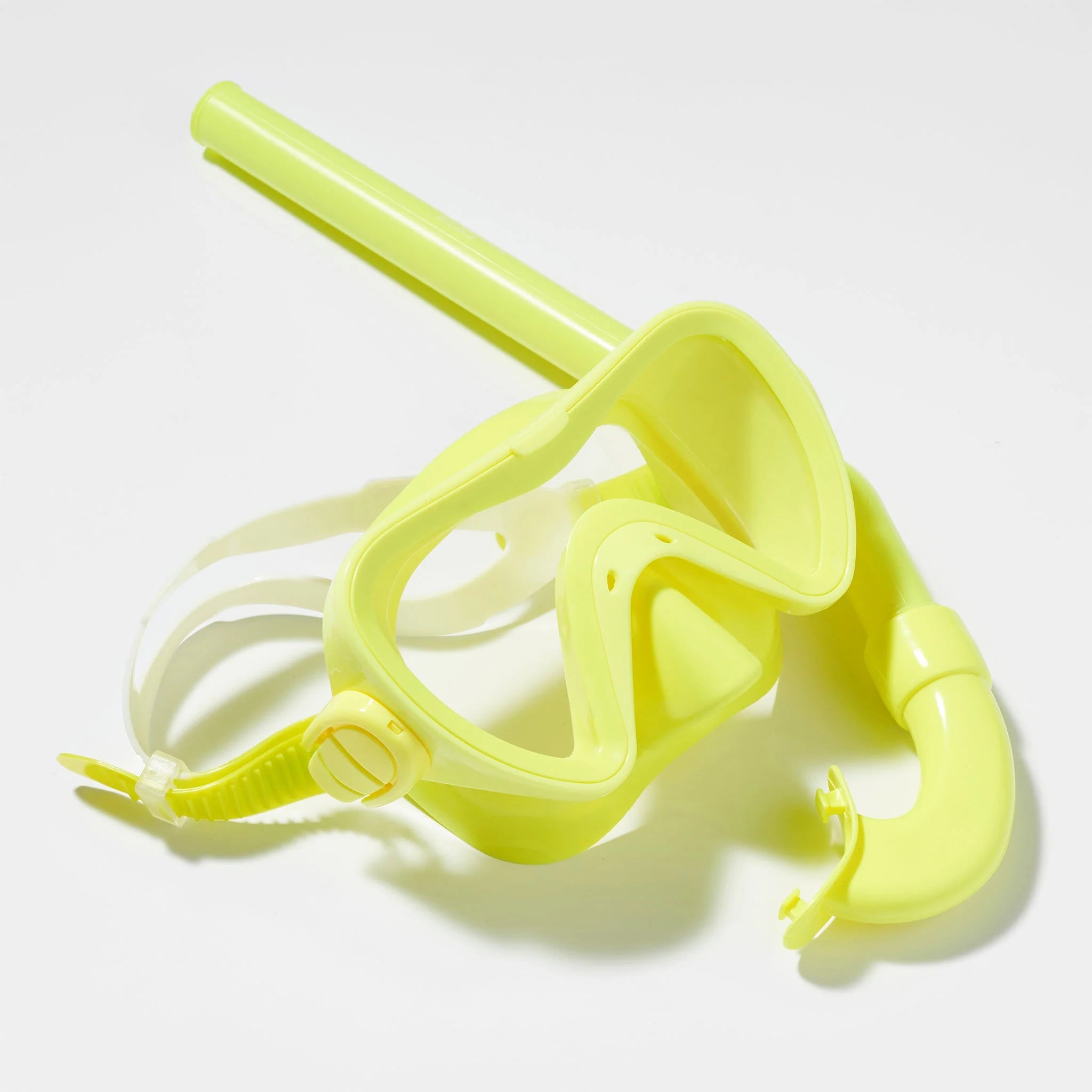 A Kids Snorkel Set Yellow by SUNNYLIFE, featuring a bright yellow snorkel tube, a matching mask with a clear front panel and adjustable white strap, and vibrant yellow flippers, is placed on a white surface.