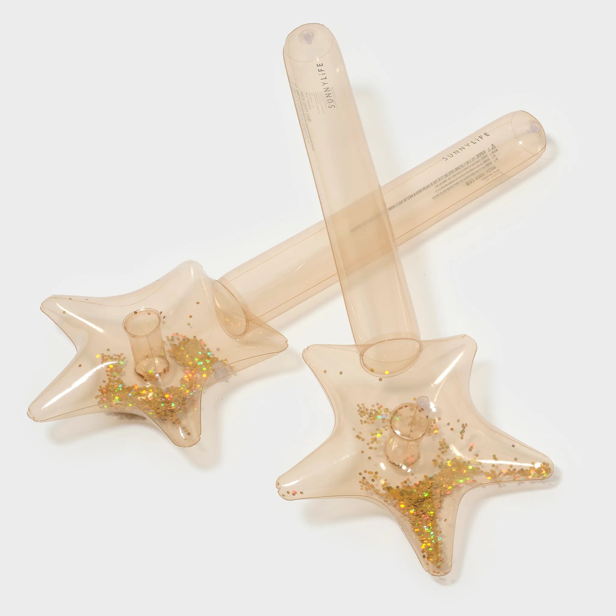 Two clear, star-shaped "Inflatable Star Wands" (Set of 2) by SUNNYLIFE, filled with gold glitter, are crossed over each other. The wands feature long, transparent handles made from phthalate-free PVC and the image is set against a plain, light background.