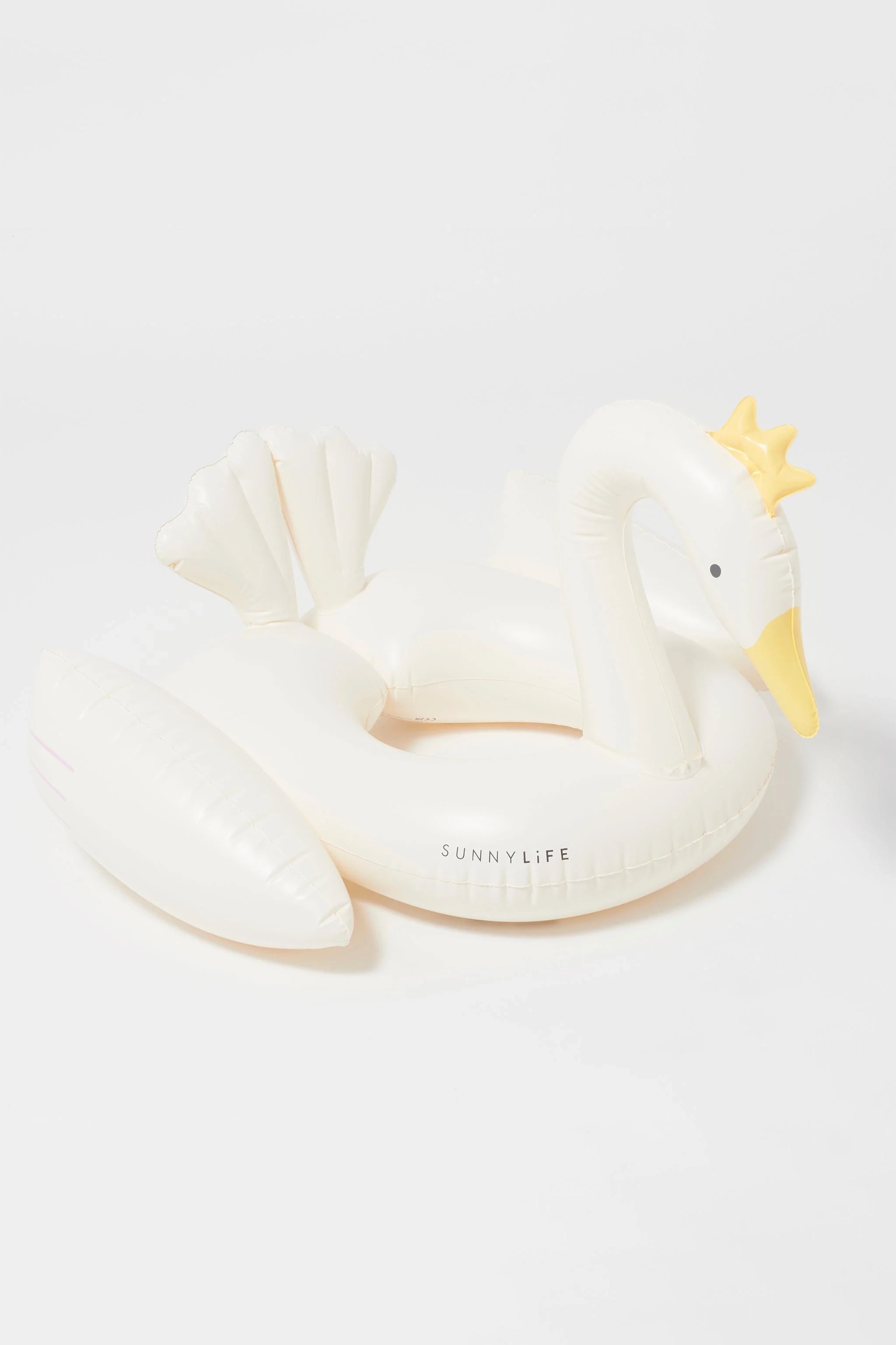 The Kids Tube Pool Ring Princess Swan by SUNNYLIFE is a durable white inflatable swan featuring a yellow beak, a small golden crown on its head, and two curved wings. Made from non-toxic PVC, the swan has "SUNNYLIFE" printed on its side against a plain white background.