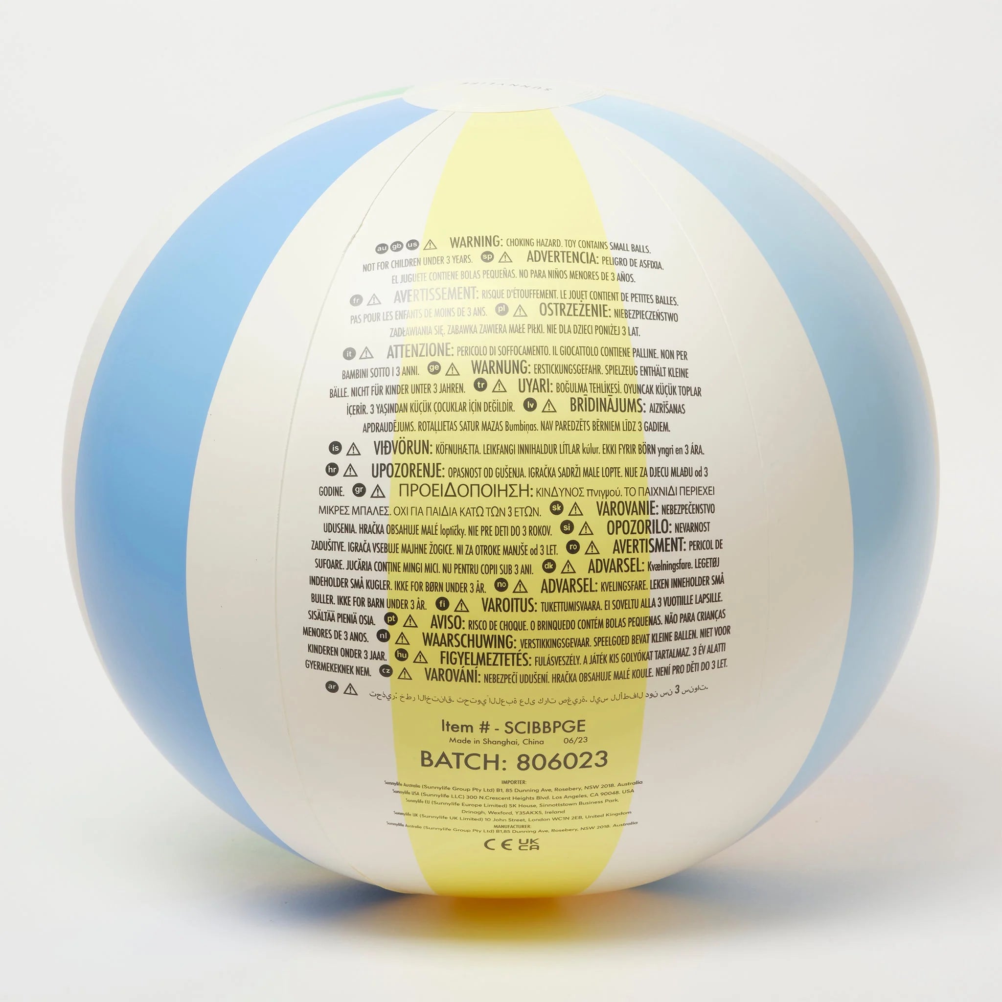 The Inflatable Beach Ball Pastel Gelato by SUNNYLIFE is a durable and vibrant PVC ball that comes in blue, white, and yellow hues. It has various printed warnings and instructions in multiple languages. Featuring the batch number "806023" and item number "SCIBBPG2" on the lower portion, this non-toxic phthalate-free beach ball is perfect for Sunnylife floats.