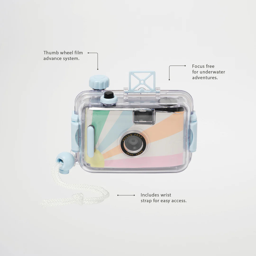 Introducing the Underwater Camera Pastel Gelato by SUNNYLIFE: a vibrant, retro-inspired film camera featuring a clear, detachable waterproof casing. It boasts a thumb wheel film advance system and a focus-free lens perfect for underwater photography. Additionally, it comes with a convenient wrist strap for easy access. This 35mm roll negative film camera is adorned in pastel rainbow colors with charming blue accents.