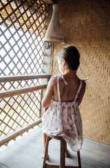 Girl sitting in a Balinese hut showing the back of Luna Pinafore