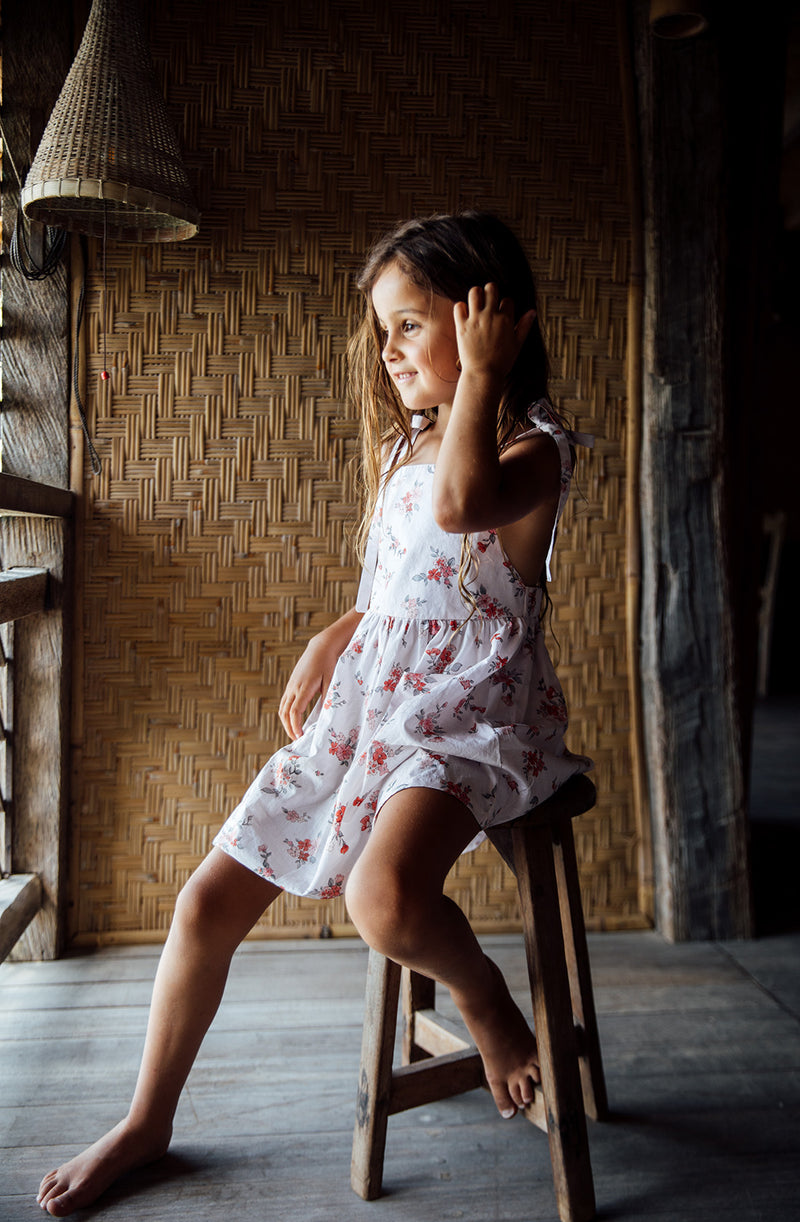 Girl sitting in Balinese hut showing the front of Luna Pinafore
