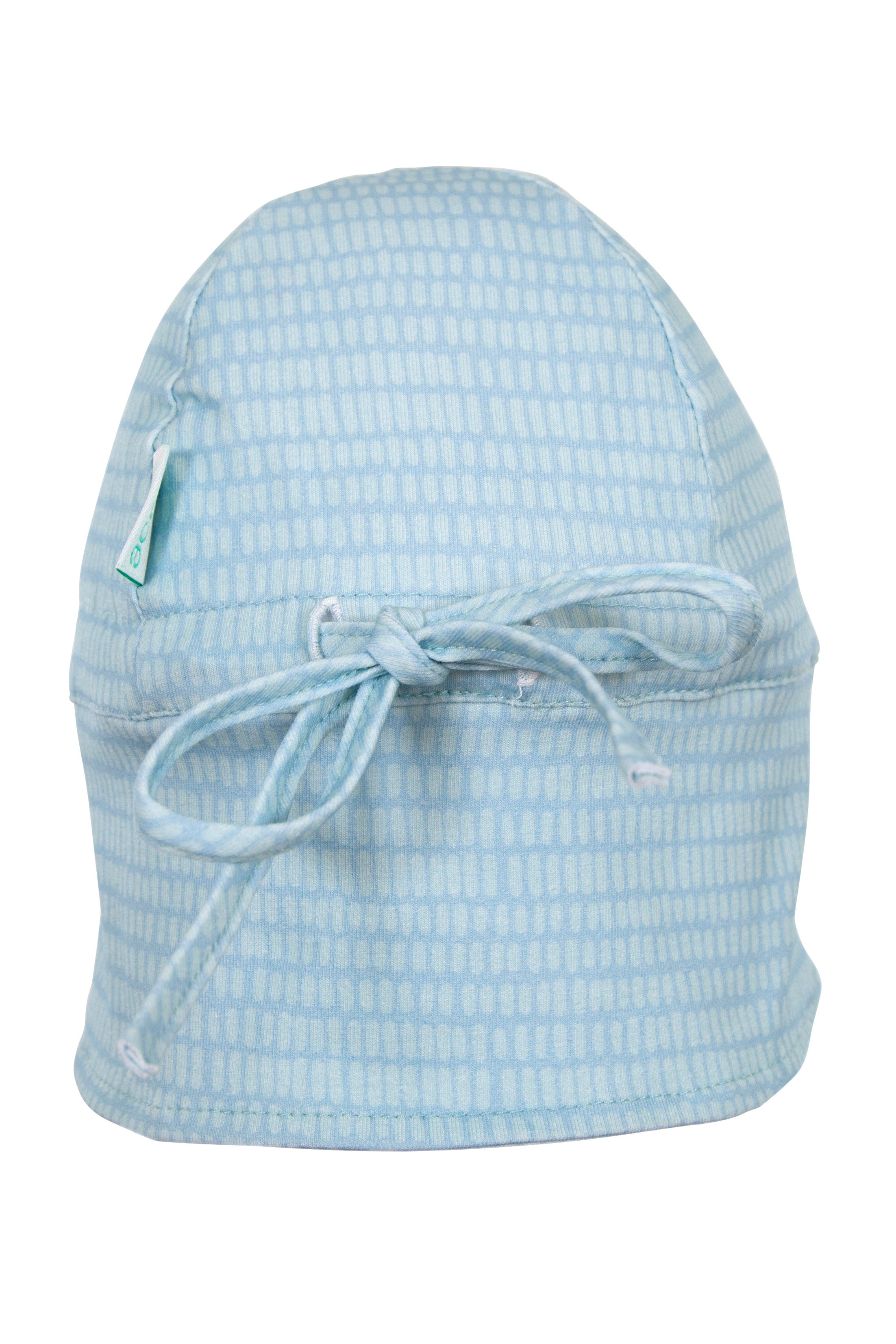 The Dashes Flap Hat Teal by ACORN KIDS is a light blue scrub cap adorned with a Rose Coloured Dashes Print. It features small, rectangular shapes in a grid pattern and includes a tied bow at the back, all crafted from 100% Cotton Jersey for both style and comfort.