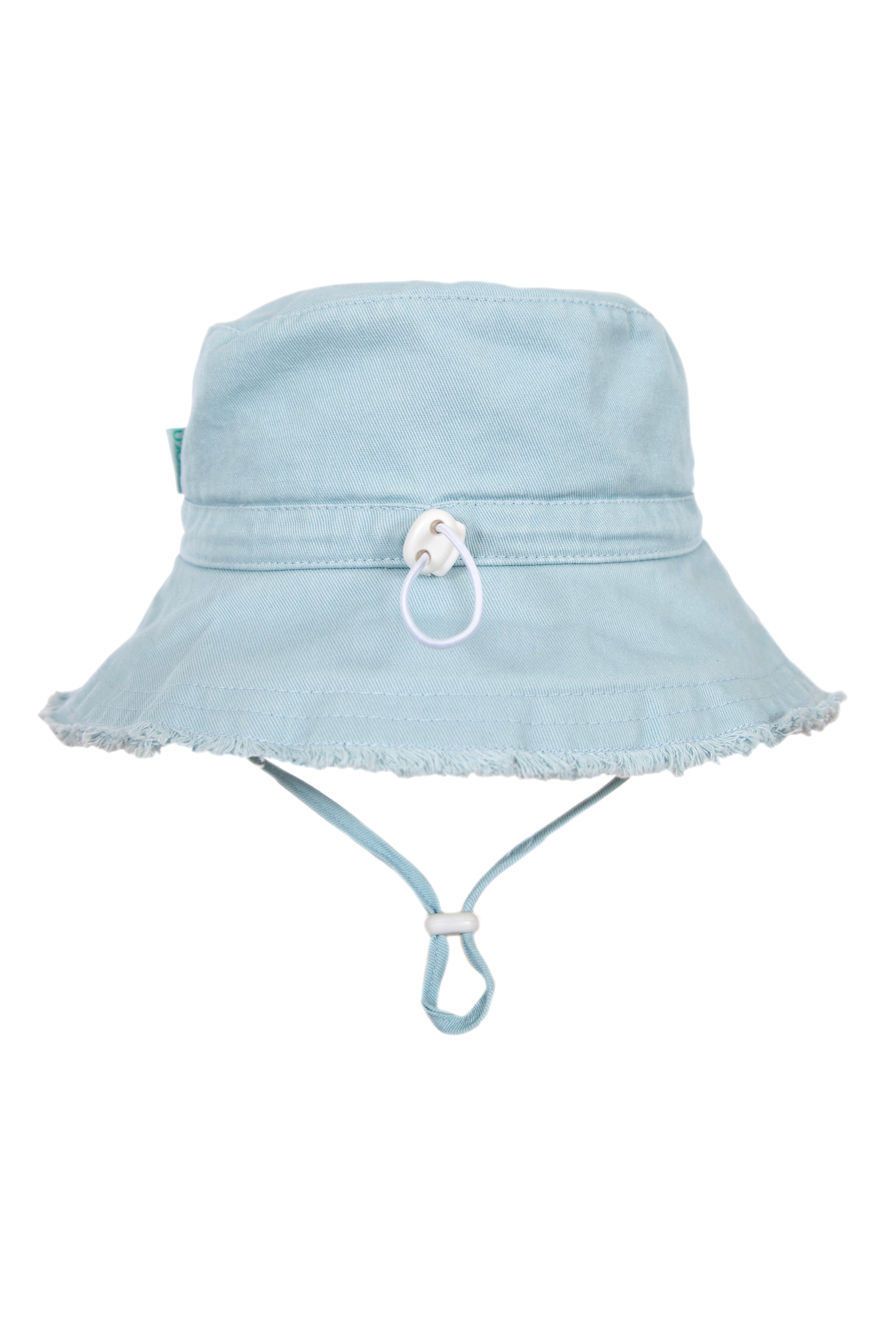 The Frayed Bucket Hat Seafoam by ACORN KIDS is made from cotton twill in a light blue shade, featuring a wide brim with a frayed edge. Ideal for sunny days, it provides UPF50+ sun protection and includes an adjustable chin strap and a loop with a small white toggle on the front.