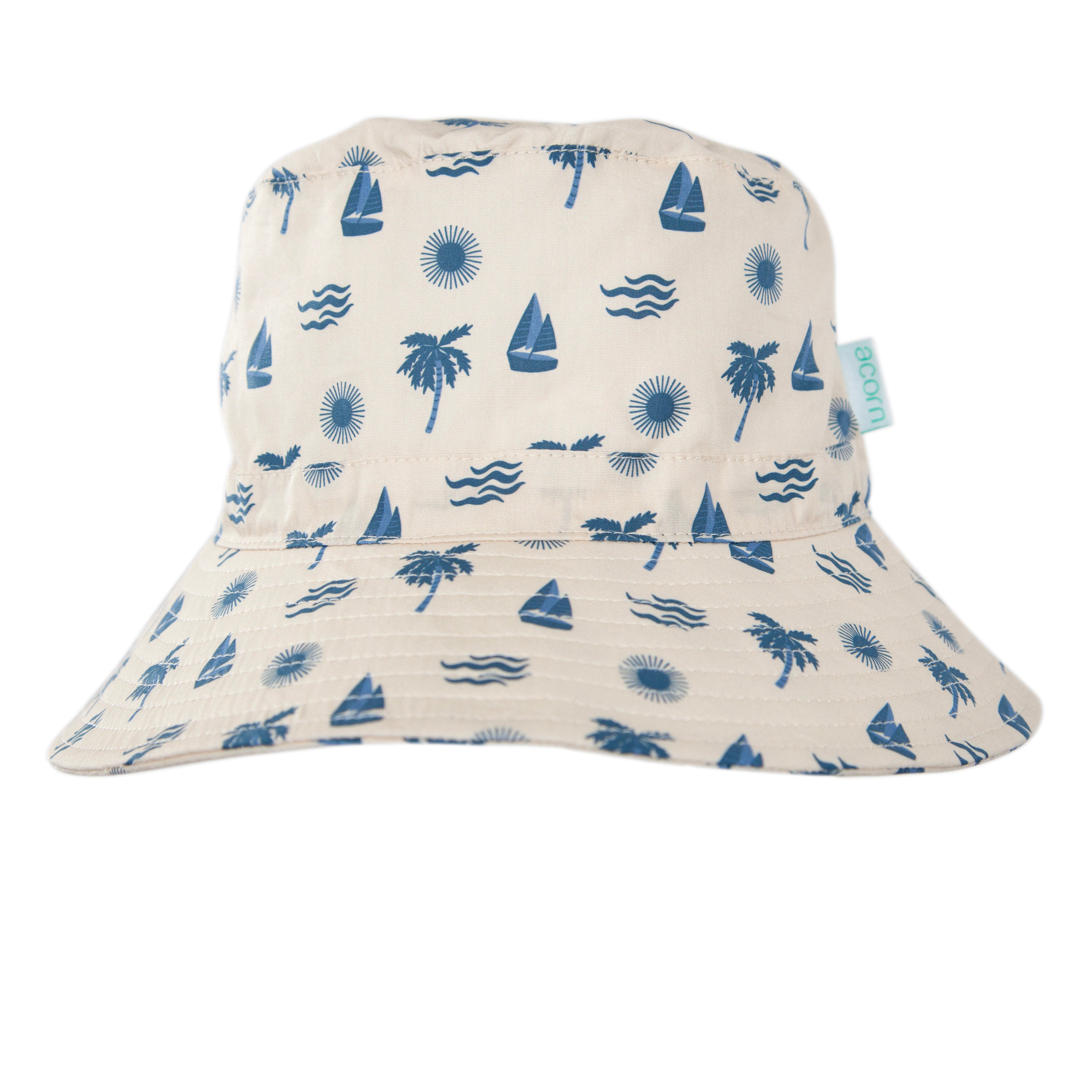 The Acorn Kids - Island Breeze Wide Brim Bucket Hat by ACORN KIDS is a light-colored cotton hat with blue sailboats, palm trees, suns, and waves. It offers UPF50+ sun protection for stylish days outdoors.