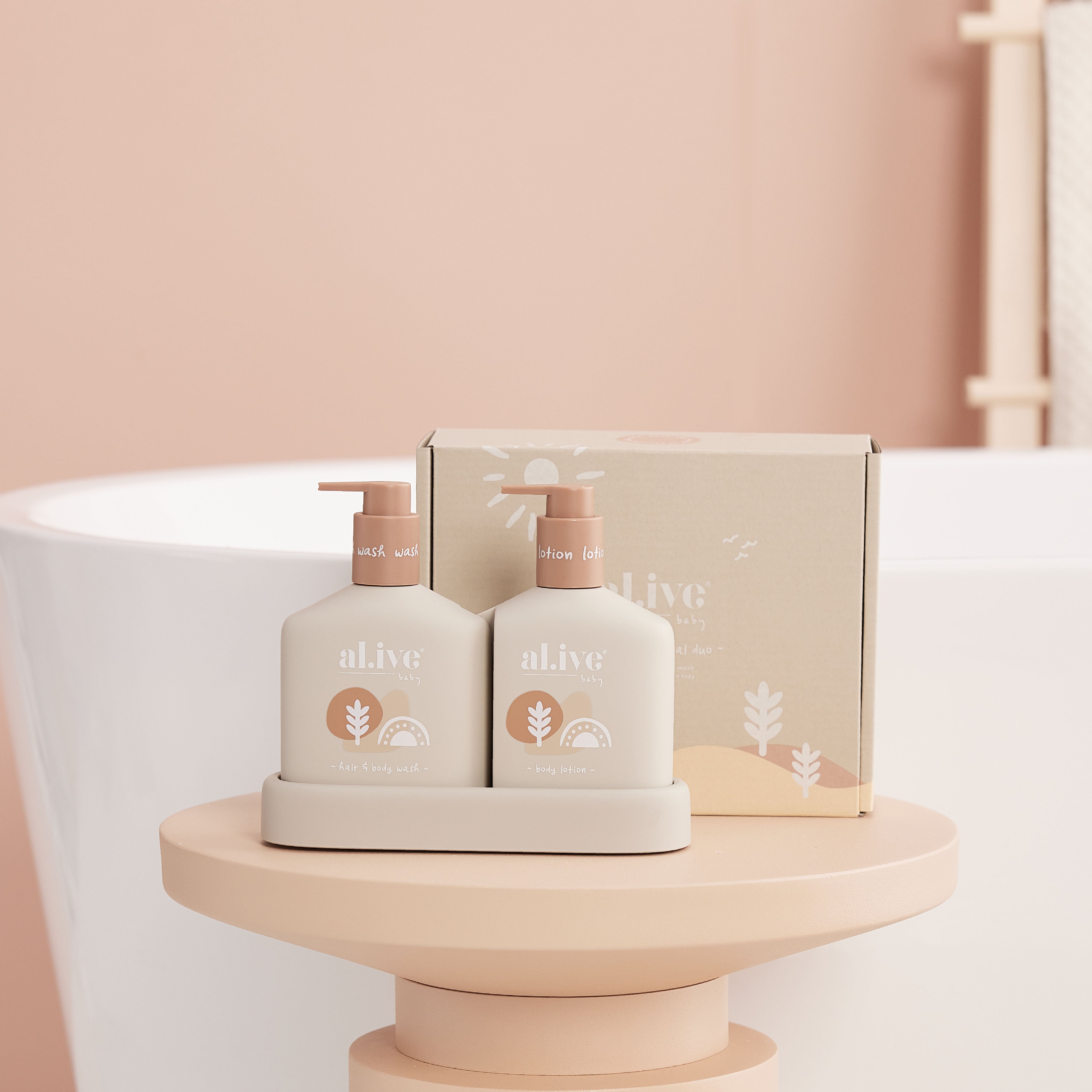 The al.ive hair and body calming oatmeal duo in a rose gold podium with a bath in the background.