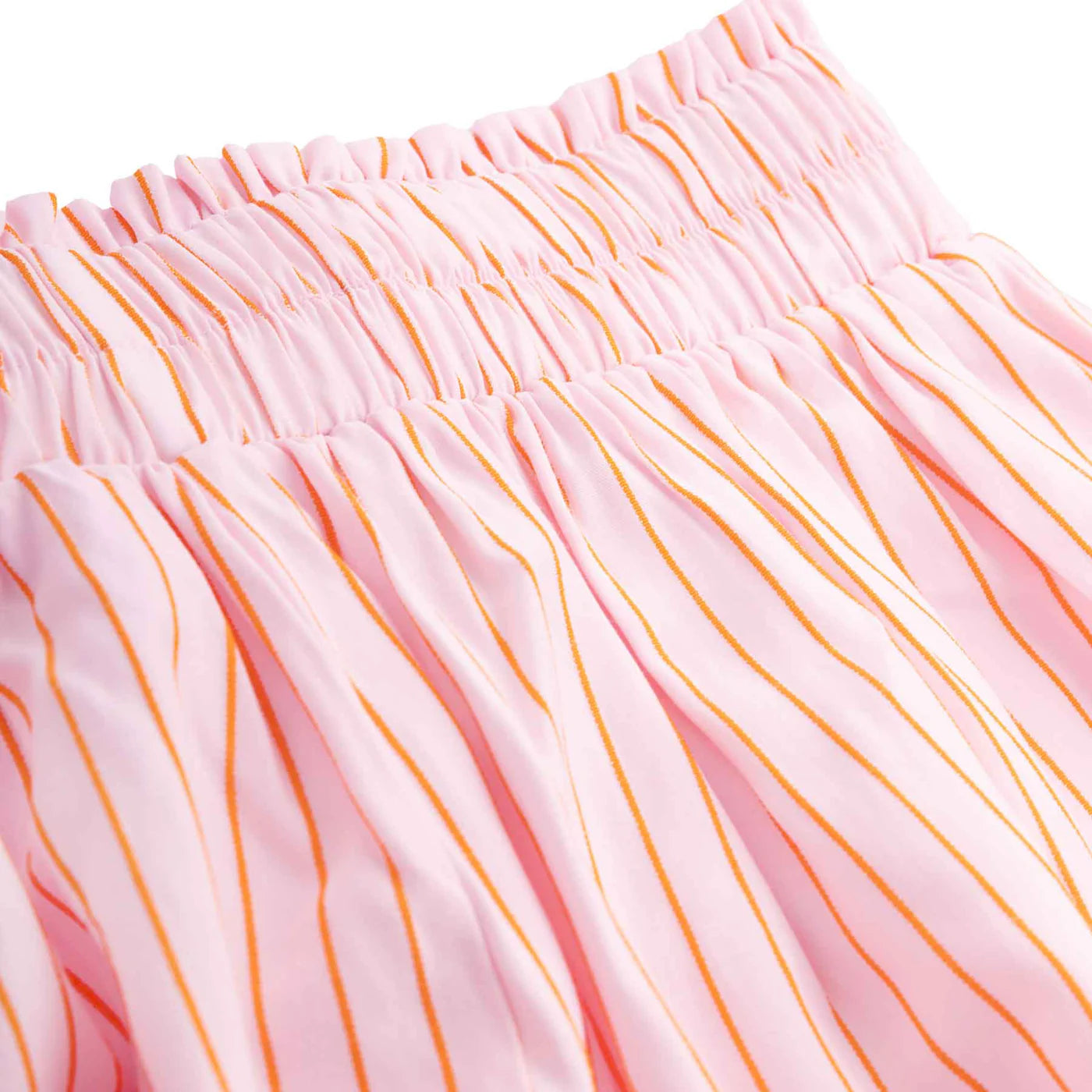 Close-up of the pink fabric featuring orange vertical stripes and a gathered elastic waistband, resembling the Mama Everyday Shorts Sunset Stripe from LITTLE THE LABEL, showcasing a lightweight and flowing texture similar to Mama Styles.