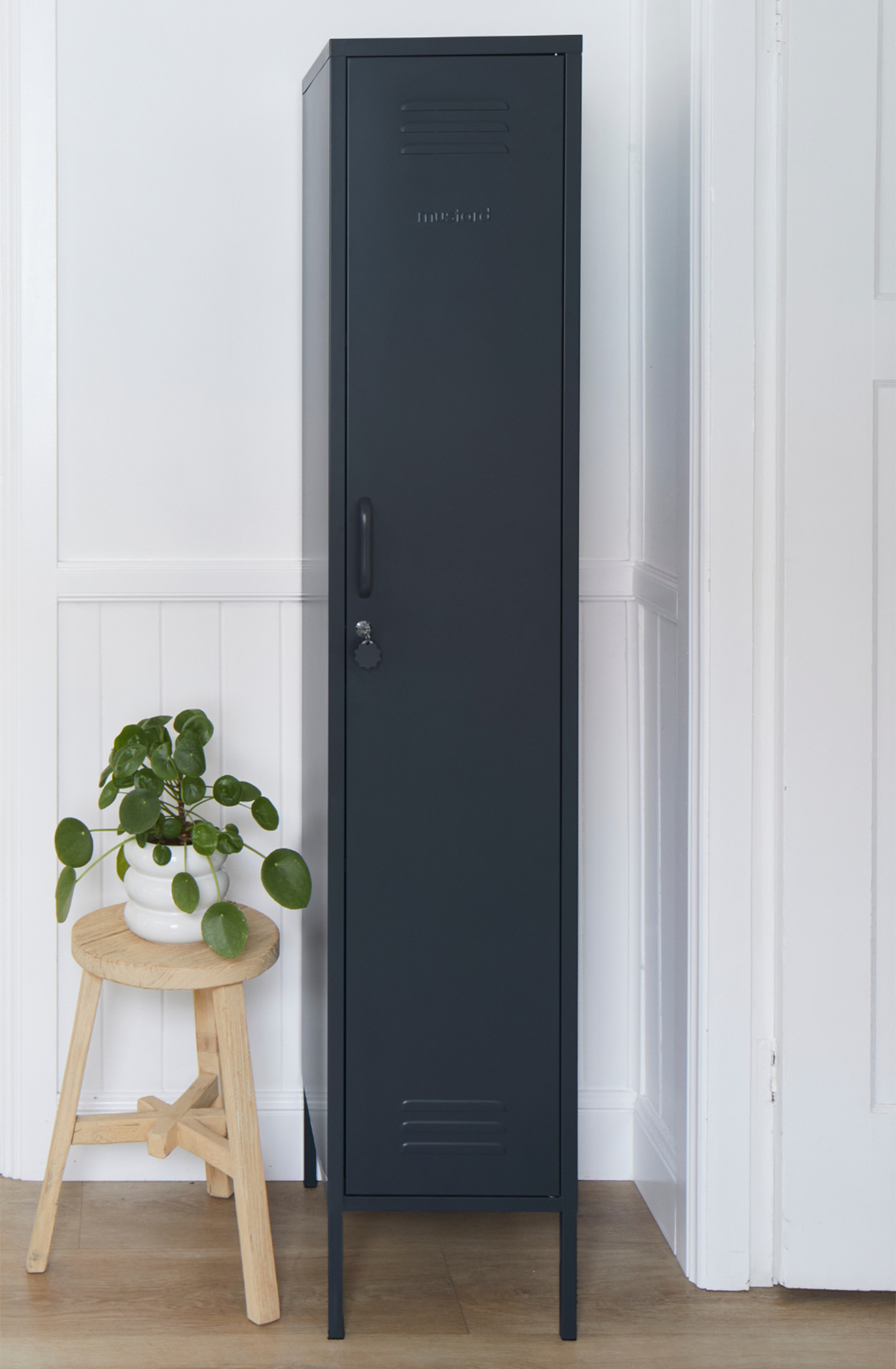 The skinny locker in slate next to a pot plant.