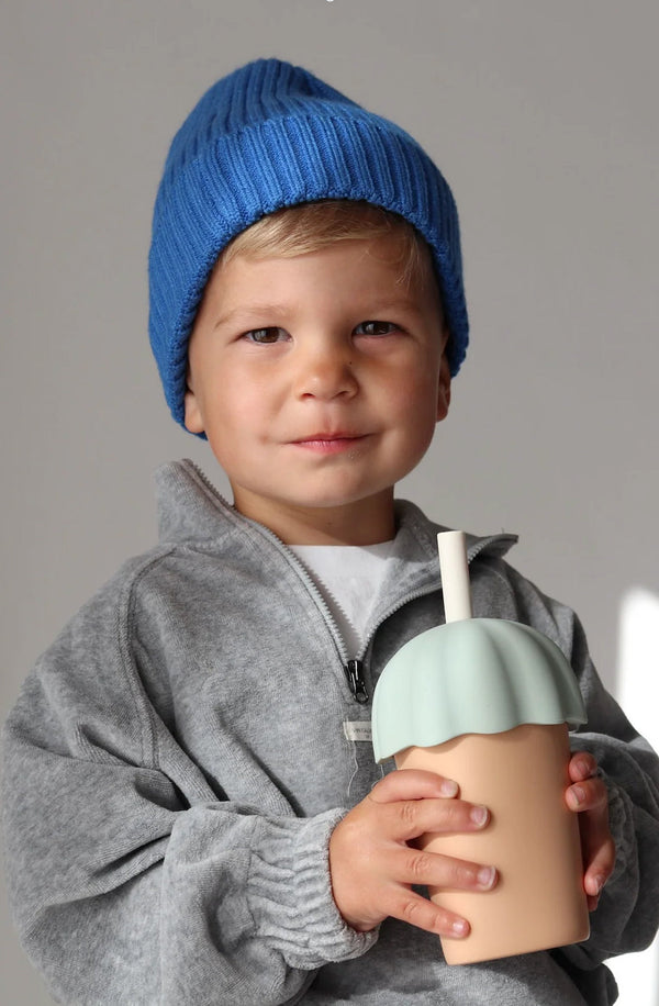 Boy in blue beanie holding his smoothie cup