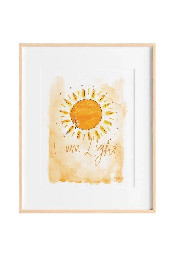 The I am Light Art Print A4 (Unframed) by SUN CHILD beautifully features a vivid yellow sun with glowing rays and the handwritten affirmation "I am Light" at the bottom, all set against a watercolor-like blend of soft orange and cream, making it ideal for kids' affirmation wall art.