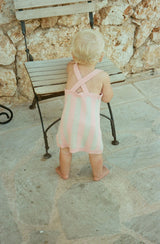 Baby standing holding onto chair showing the back of rosa knit dress