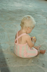 Baby sitting on the ground wearing the rosa knit dress