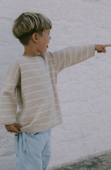 Boy pointing into the distance wearing the citrus striped knit