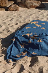 Dino swaddle laid on cot mattress in the sand at the beach