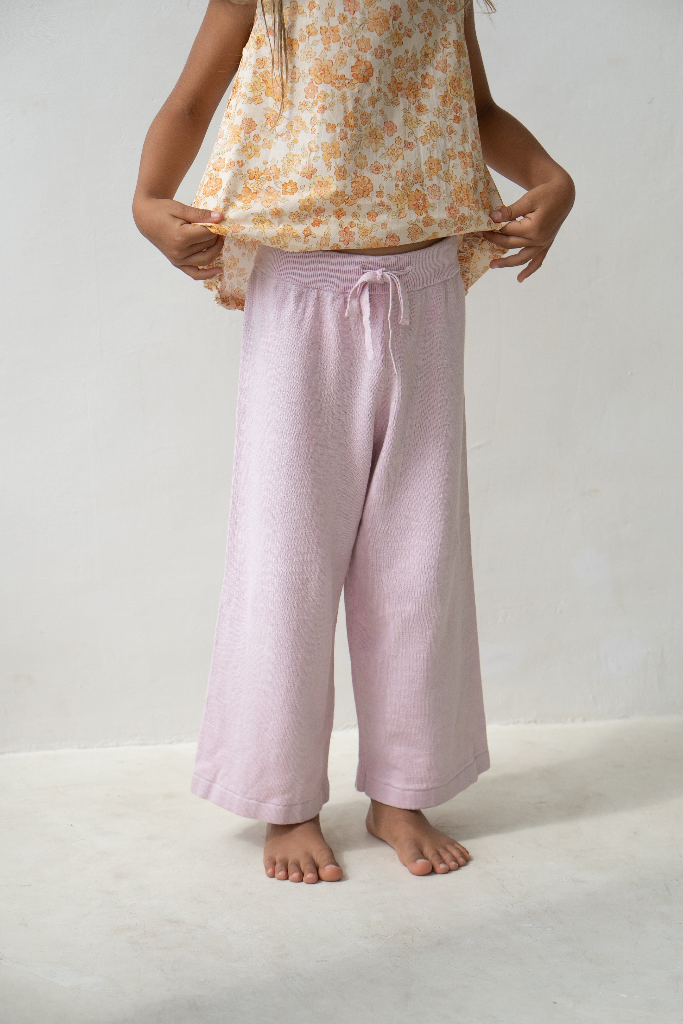 Young girl wearing thin knit pants in sweet pea.