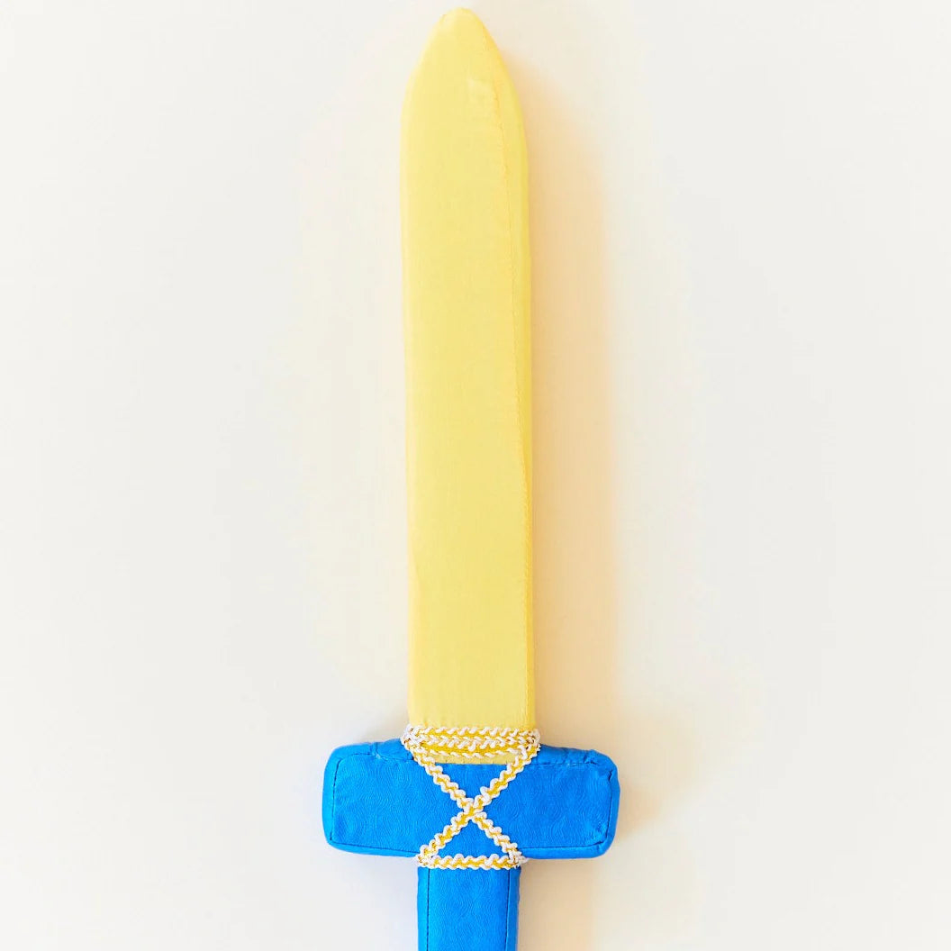 The Blue Soft Sword by SARAH'S SILKS is ideal for active play, boasting a yellow blade and a blue hilt with gold trim. Perfect for imaginative pretend play, this plush toy sword is displayed vertically against a white background, ready to inspire creative adventures.