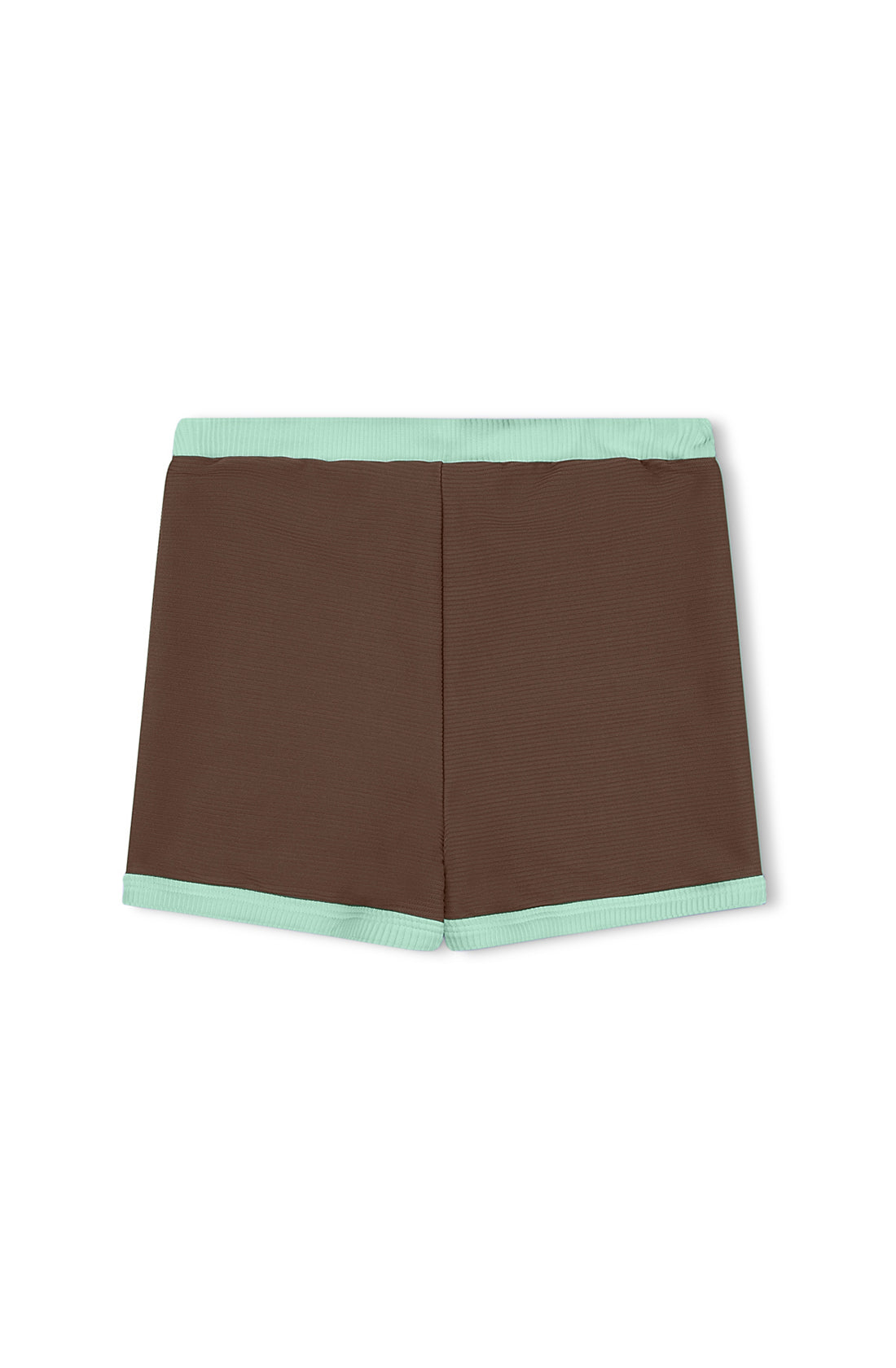 The Mini Rib Surf Short in Cacao by ZULU & ZEPHYR is a pair of square-cut swim shorts featuring a chocolate brown fabric with light green trim at the waistband and leg openings. Made from ECO MADE Recycled Spandex, the design is simple and seamless without visible branding or embellishments. The shorts are laid flat and viewed from the back.