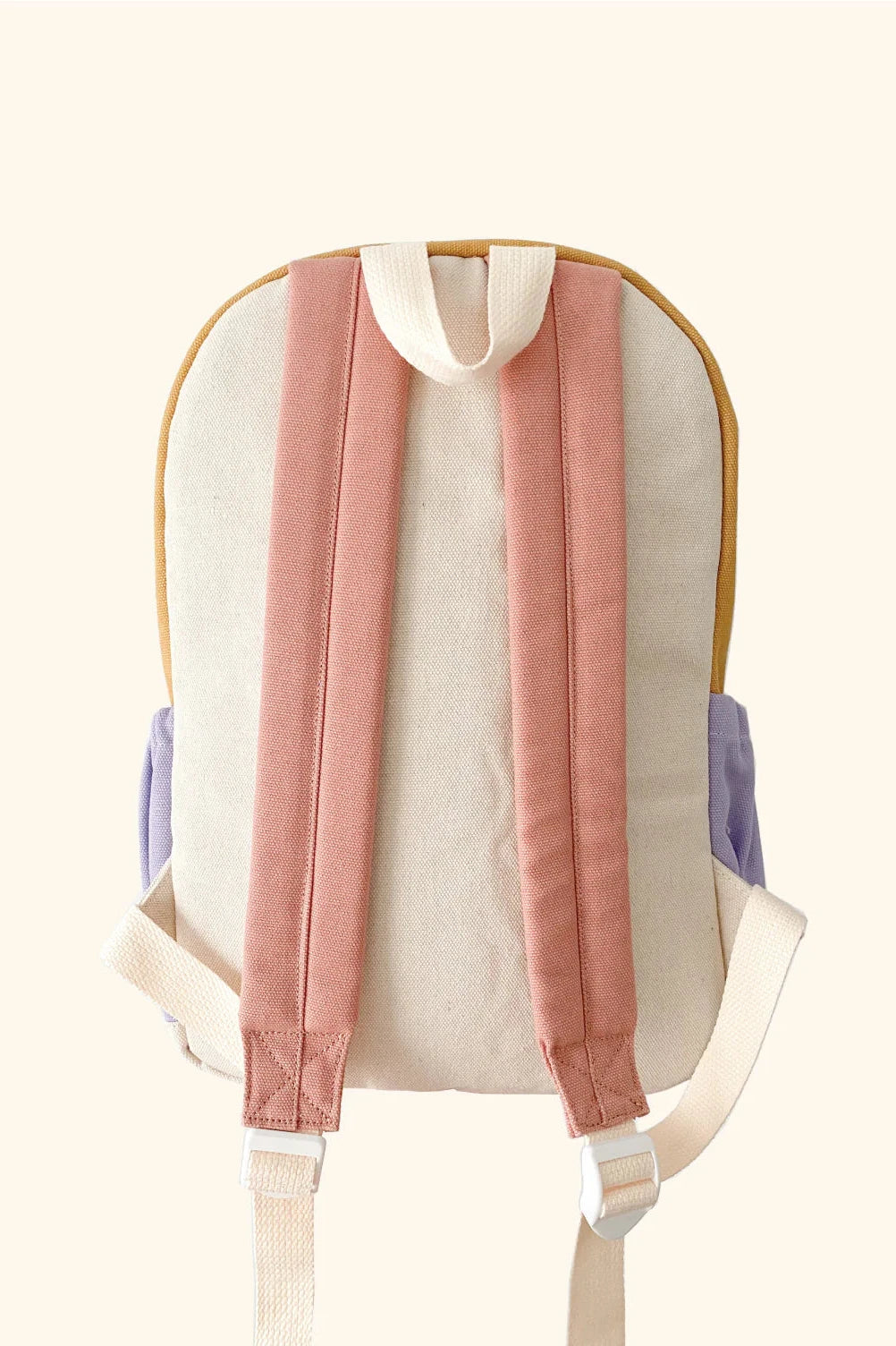 The Mimi Backpack by ZEPHII is a stylish and versatile accessory, featuring pastel-colored straps. Its main body boasts a beige color complemented by pink shoulder straps and cream-colored accents, with the sides offering a bold light purple design against a neutral background.