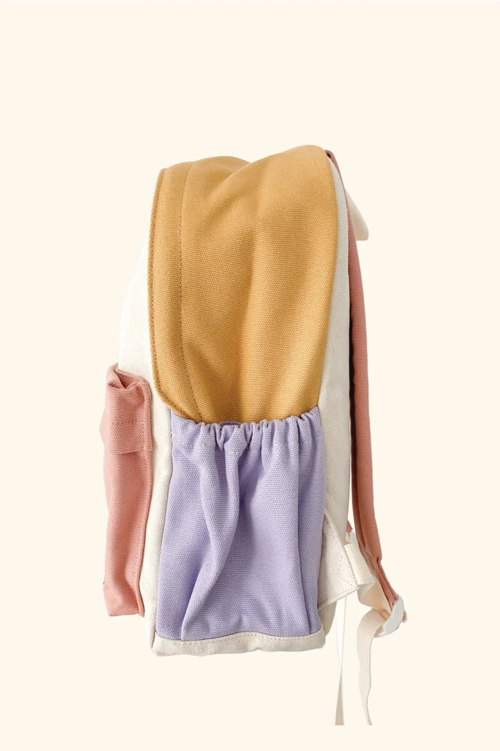 Side view of the vibrant and versatile Mimi Backpack by ZEPHII showcasing a mustard yellow top, pastel peach and lilac side pockets, a beige base, and a light pink back. The plain, light background highlights its bold colorway design.